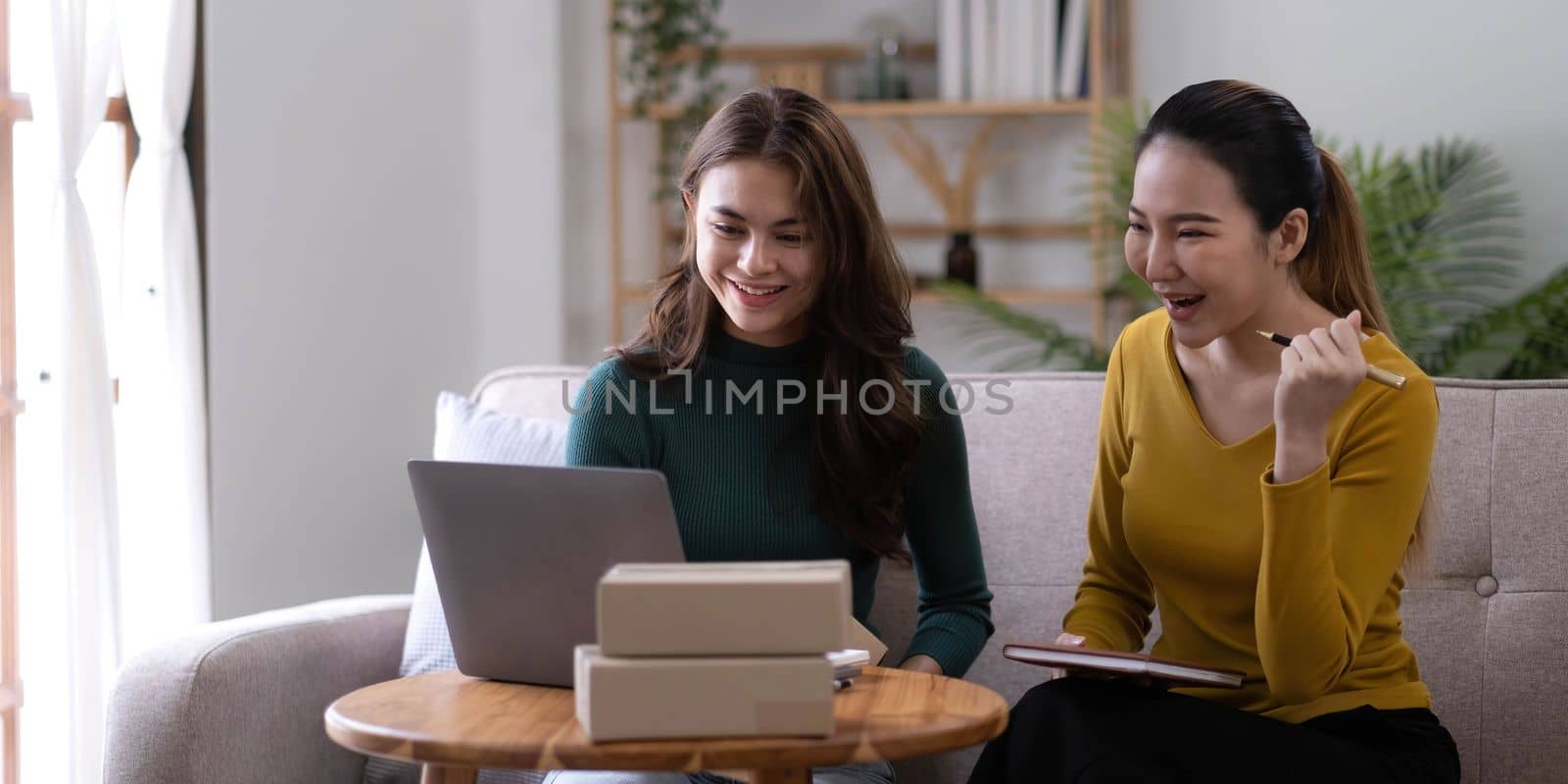 Portrait of Starting small businesses SME owners, two Asian woman check online orders Selling products working with boxs freelance work at home office, sme business online small medium enterprise.