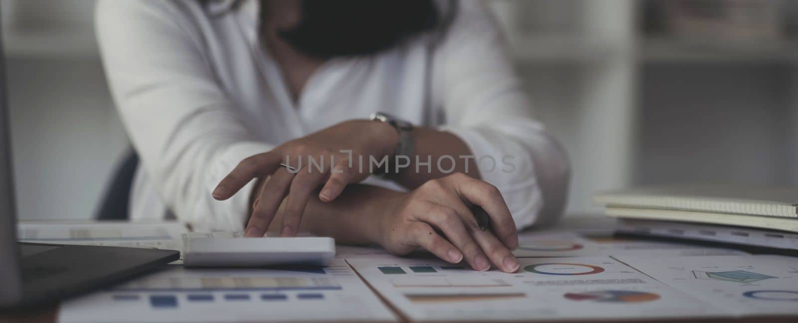 Business woman using calculator for do math finance on wooden desk in office and business working background, tax, accounting, statistics and analytic research concept.