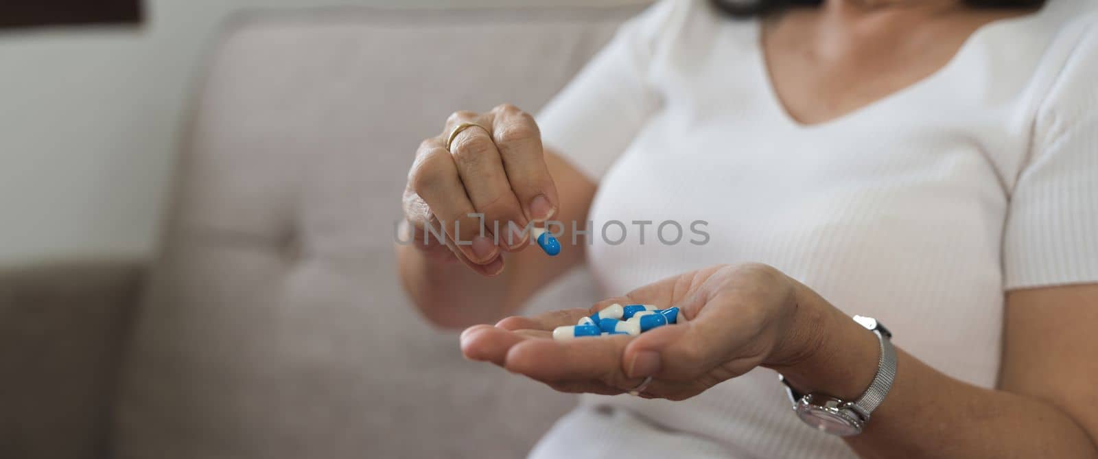 Elderly sick ill woman hold pills on hand pouring capsules from medication bottle take painkiller supplement medicine, old senior people pharmaceutical healthcare treatment concept, close up view.