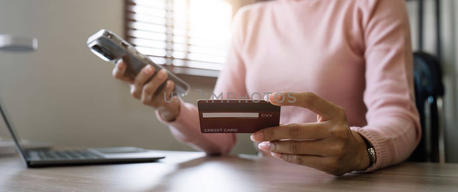 Close up young woman makes an online payment for a purchase with credit card. Online shopping with mobile phone