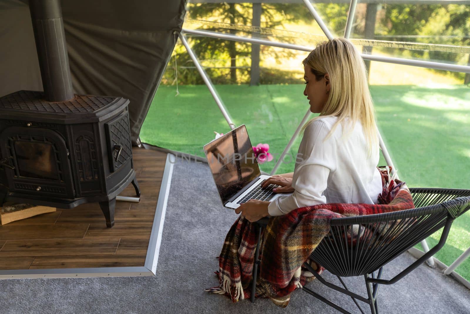 Transparent bubble tent at glamping, Lush forest around and interior. Woman with laptop by Andelov13