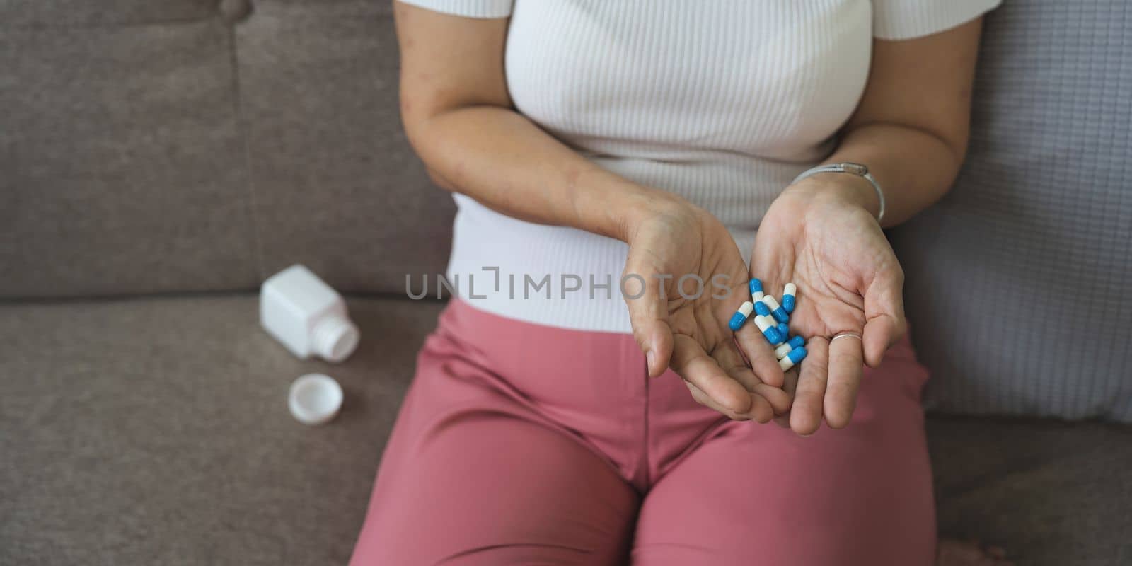 Elderly sick ill woman hold pills on hand pouring capsules from medication bottle take painkiller supplement medicine, old senior people pharmaceutical healthcare treatment concept, close up view.