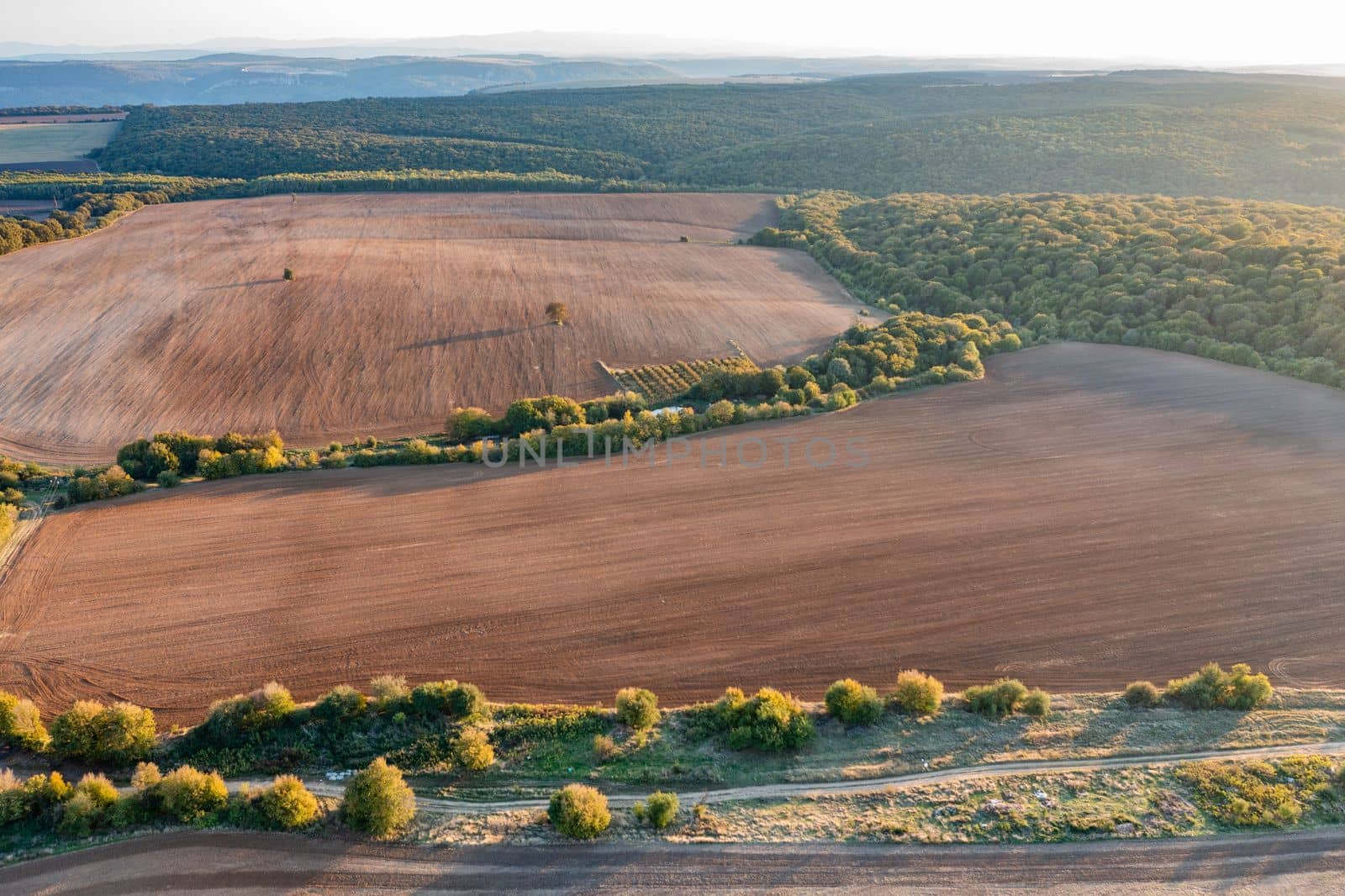 vast aerial view from drone to countryside with agricultural fields. 
