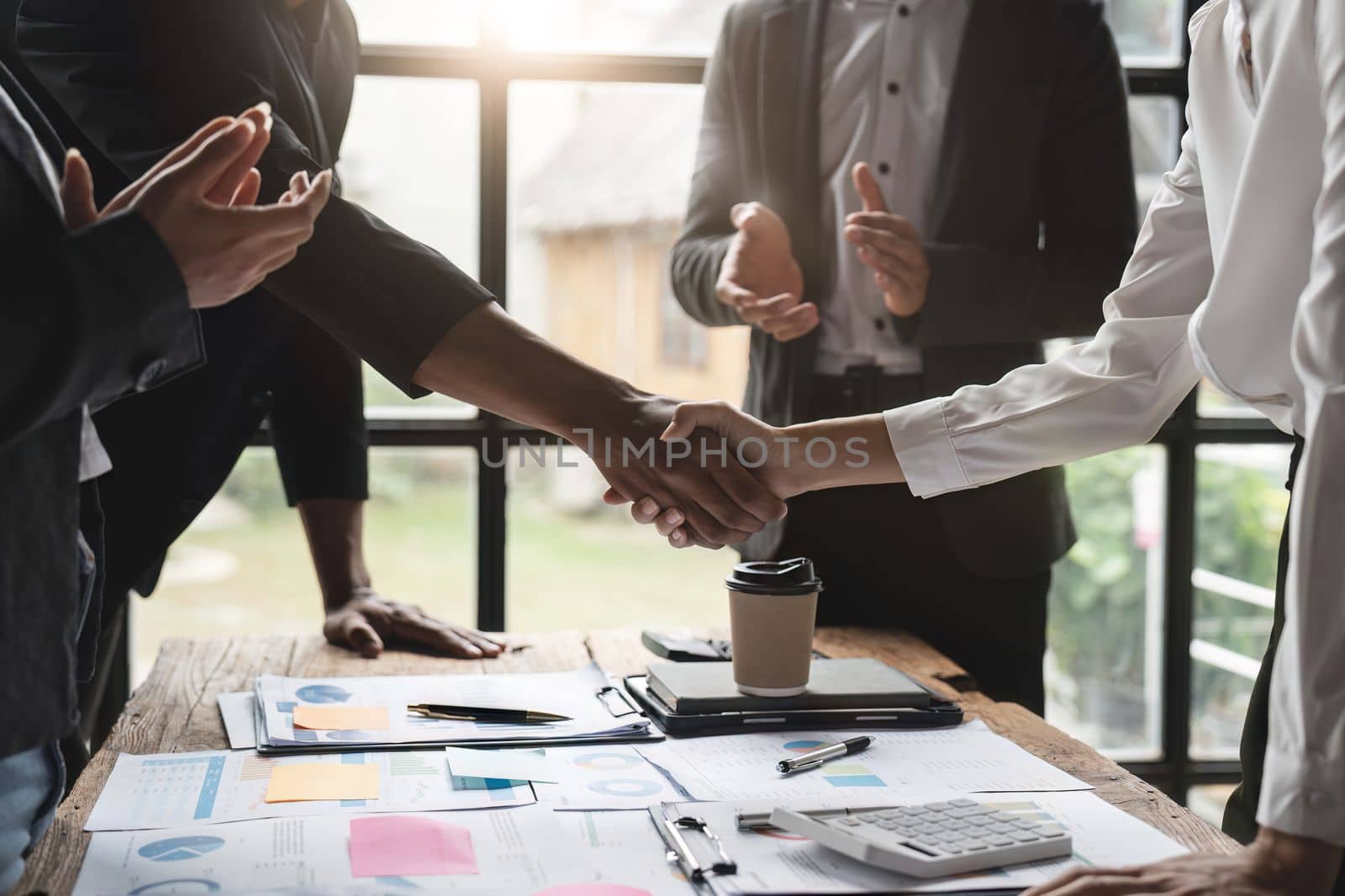 Group business people handshake at meeting table in office together with confident. Young businessman and businesswoman workers express agreement of investment deal. by nateemee