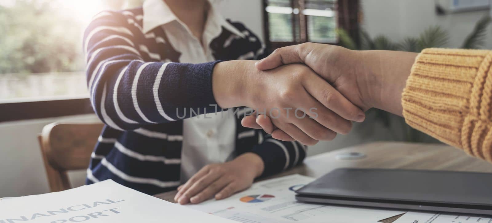 Close up of Business people shaking hands, finishing up meeting, business etiquette, congratulation, merger and acquisition concept by wichayada