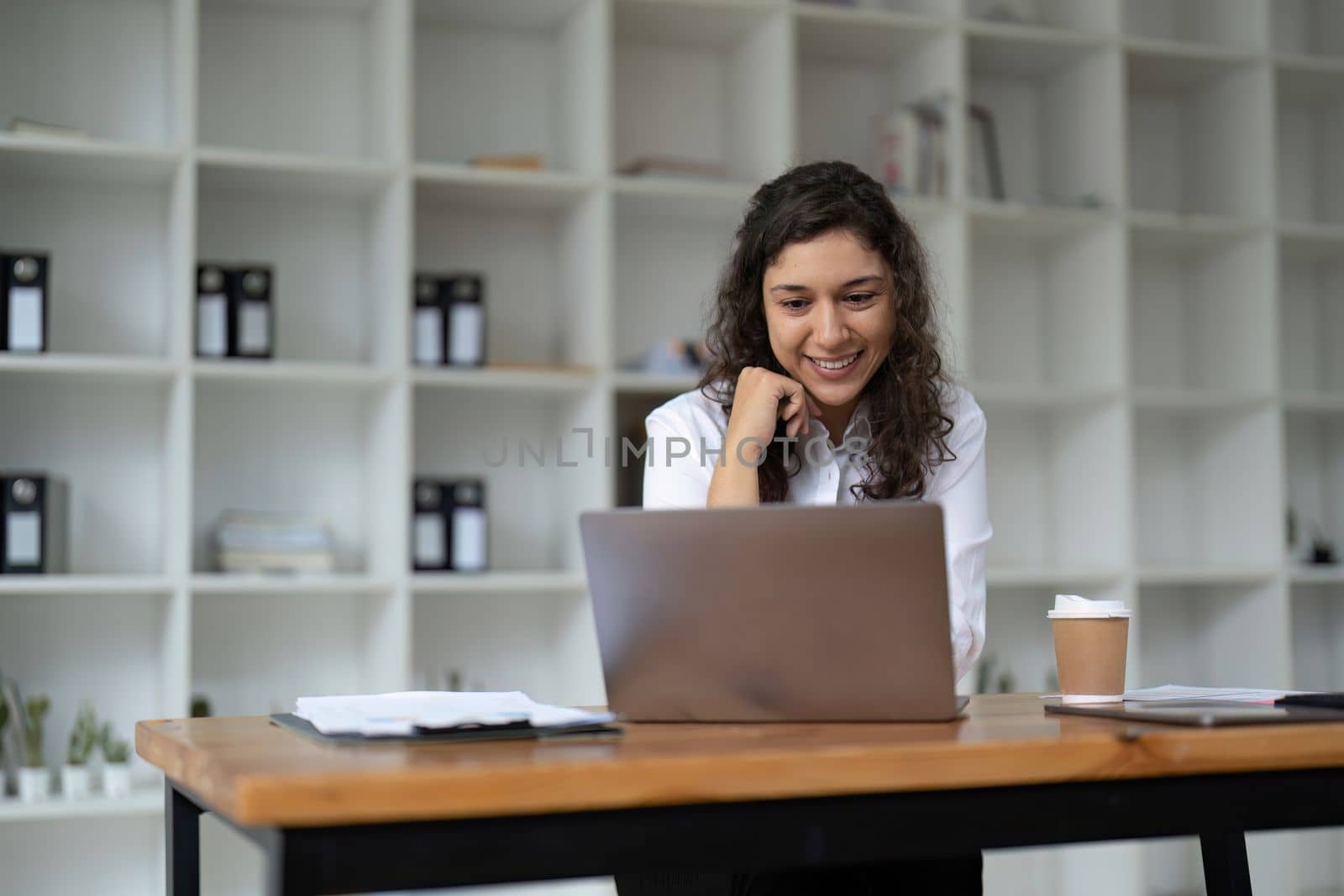 Confident businesswoman working on laptop at her workplace at modern office