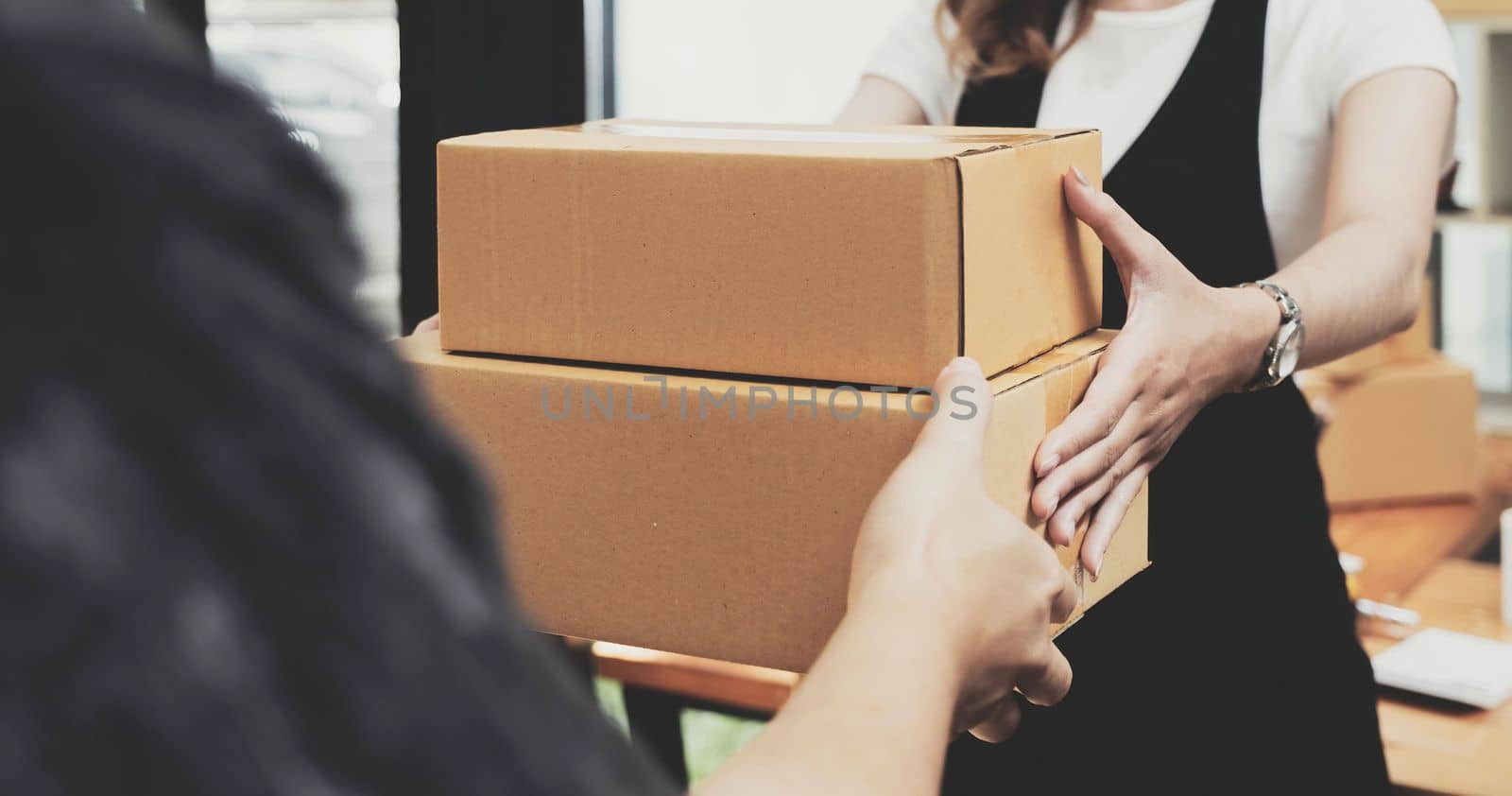 Closeup female hand accepting a delivery of boxes from deliverywoman. by wichayada