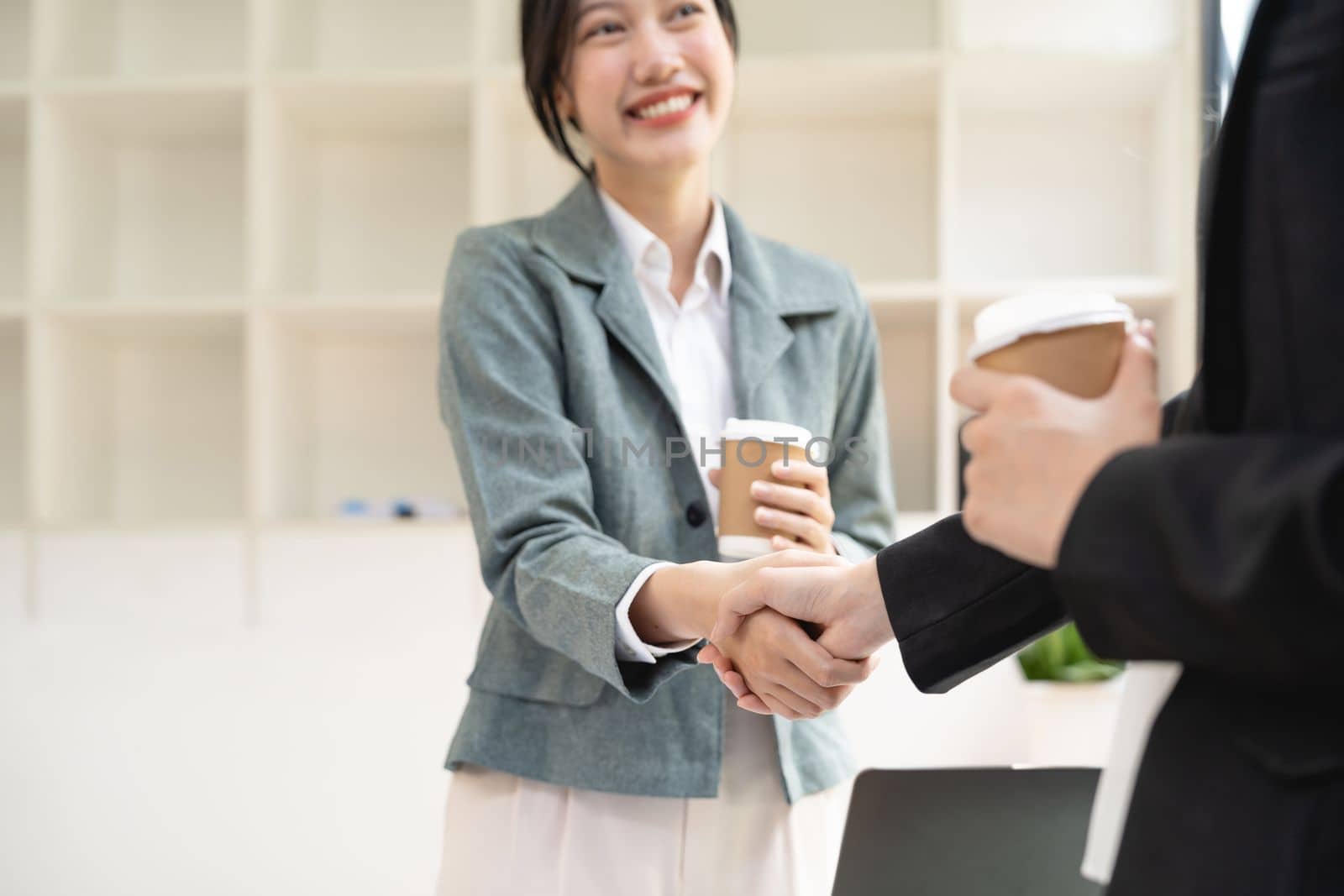 Handshake of businesspeople. Two asian female hand makes a handshake in the office.