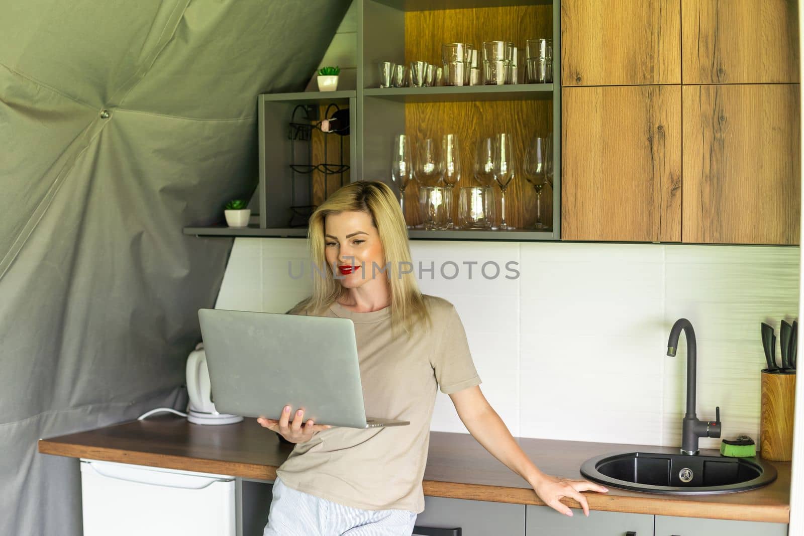 Image of young pleased happy cheerful cute beautiful business woman using laptop computer listening by Andelov13