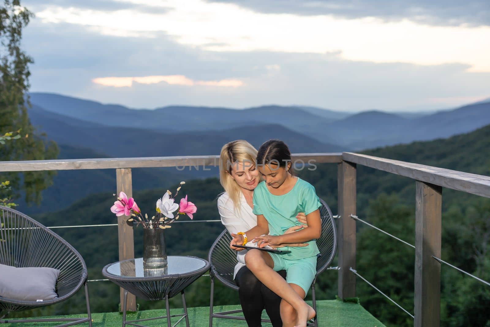 mother and daughter with a tablet on the terrace.