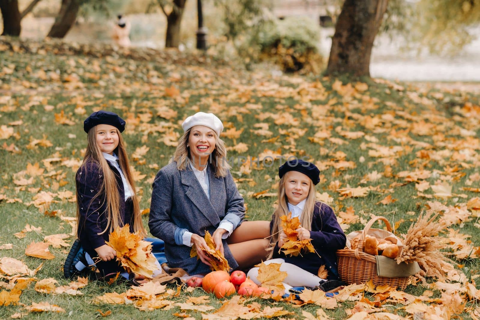 A big family on a picnic in the fall in a nature park. Happy people in the autumn park.