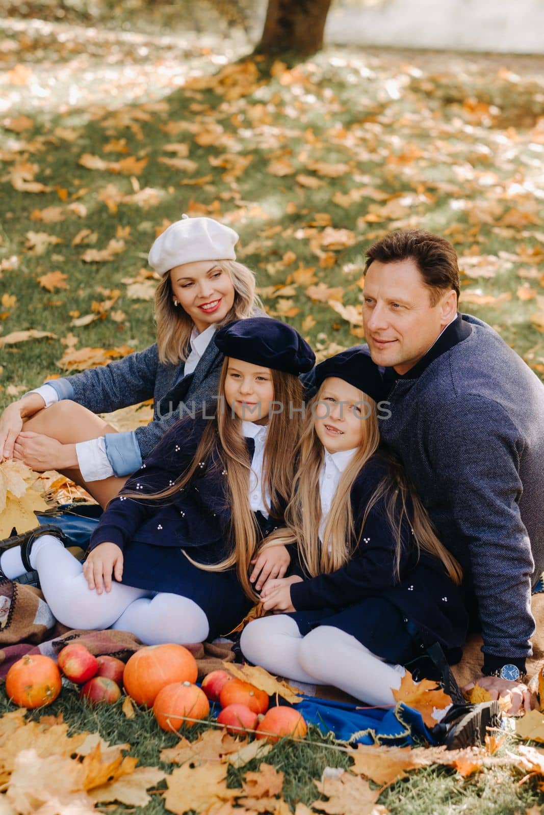 A big family on a picnic in the fall in a nature park. Happy people in the autumn park by Lobachad