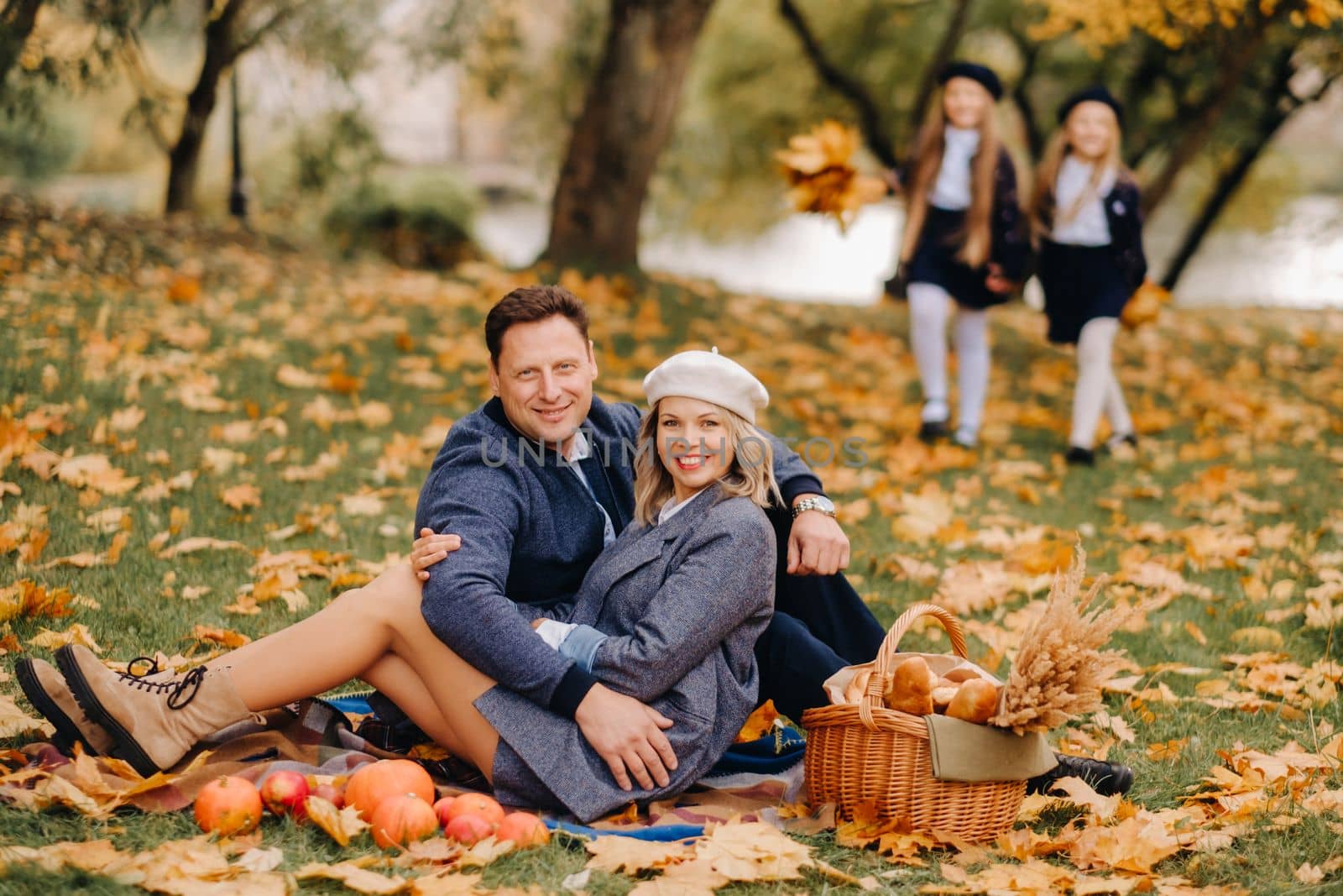 A big family on a picnic in the fall in a nature park. Happy people in the autumn park.