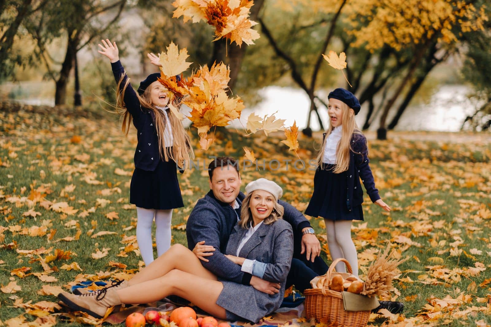 A big family on a picnic in the fall in a nature park. Happy people in the autumn park.