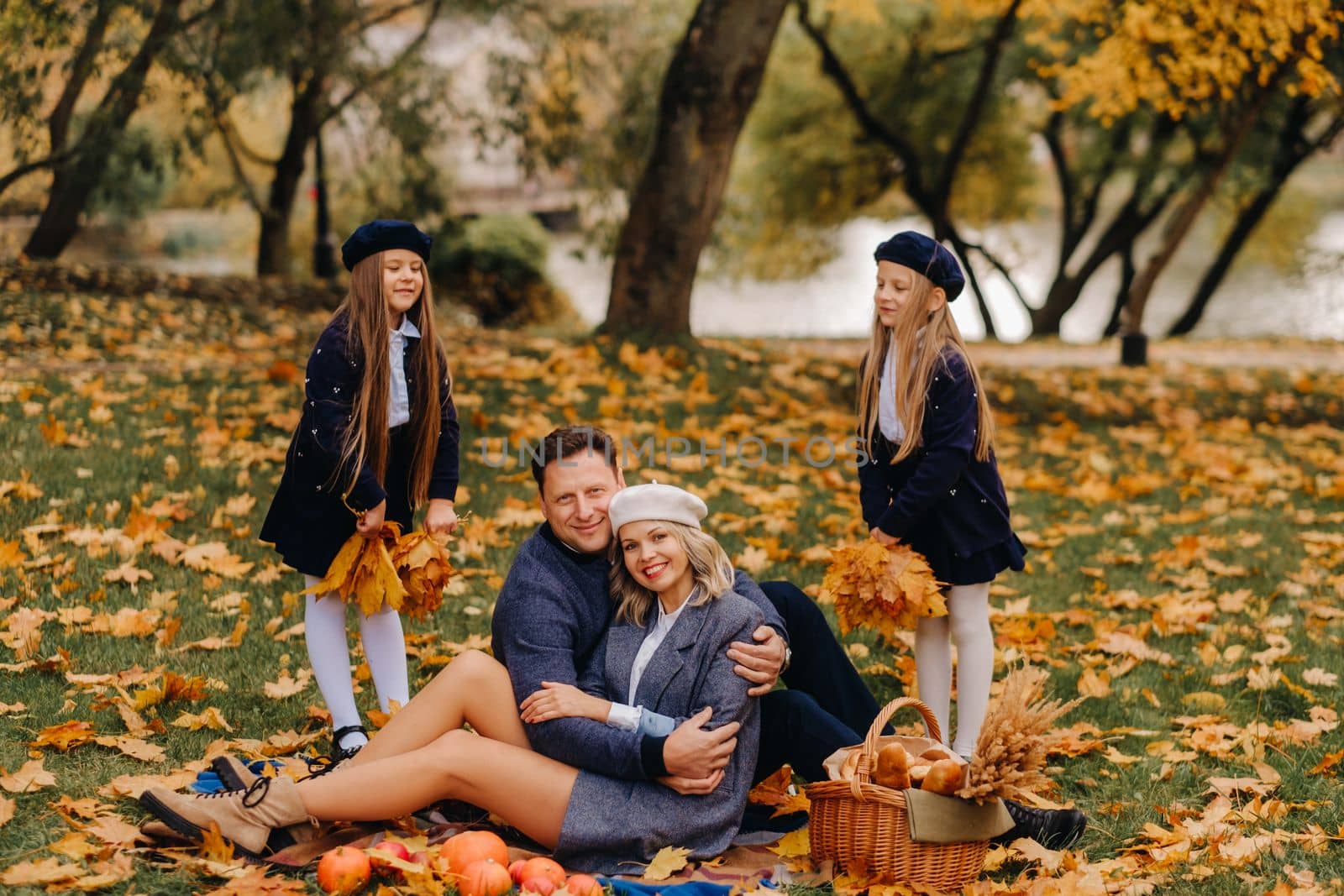 A big family on a picnic in the fall in a nature park. Happy people in the autumn park.