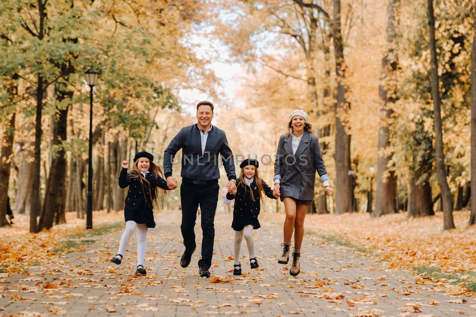 A large family walks in the park in the fall. Happy people in the autumn park.