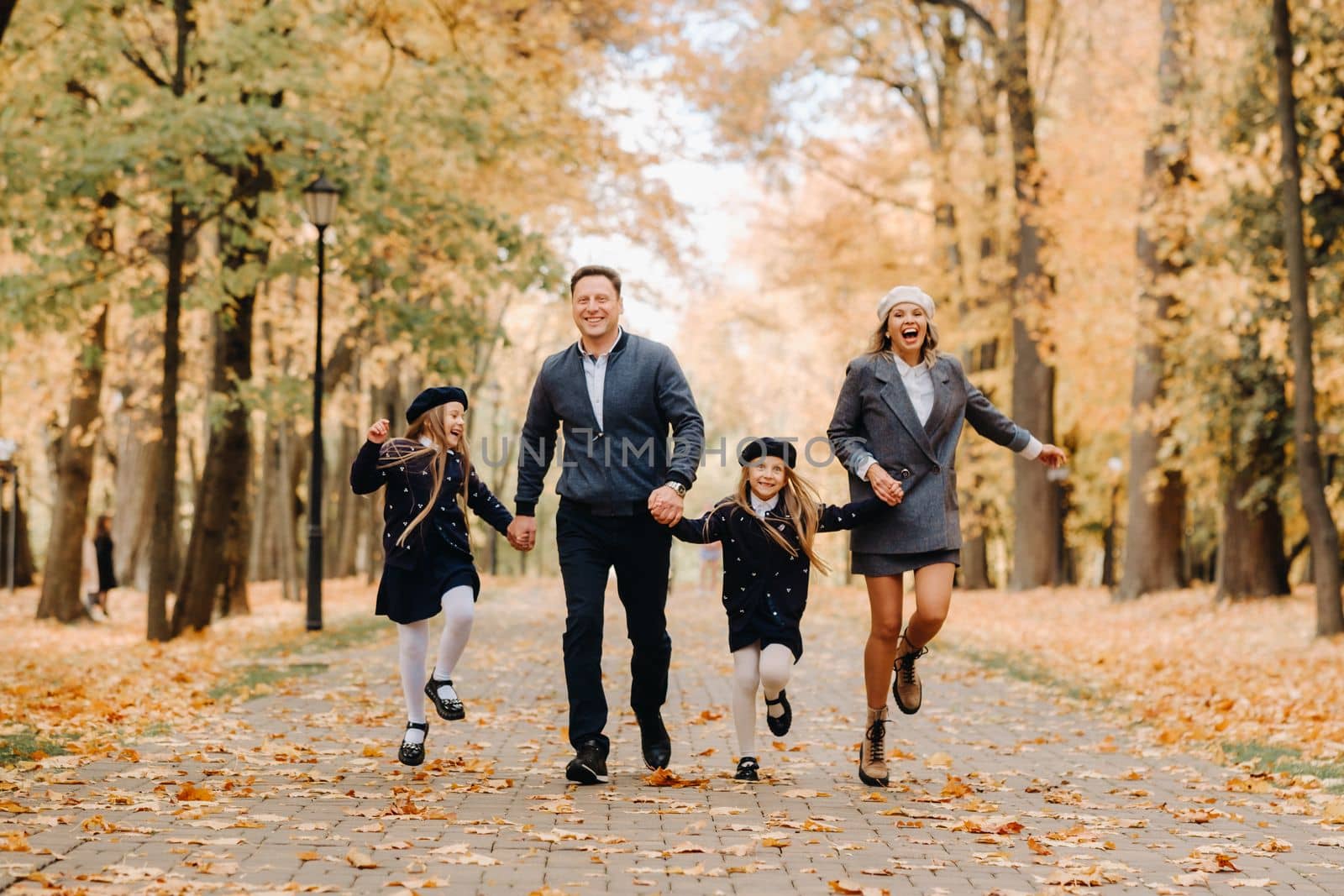 A large family walks in the park in the fall. Happy people in the autumn park.