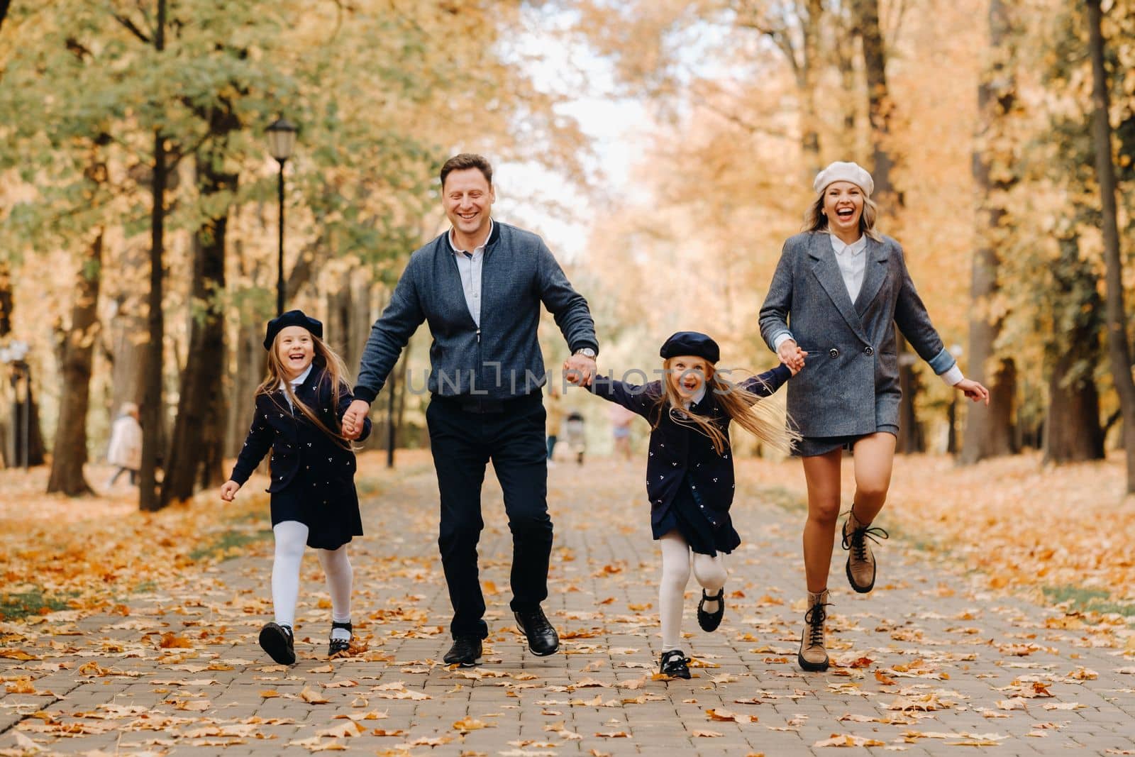 A large family walks in the park in the fall. Happy people in the autumn park.