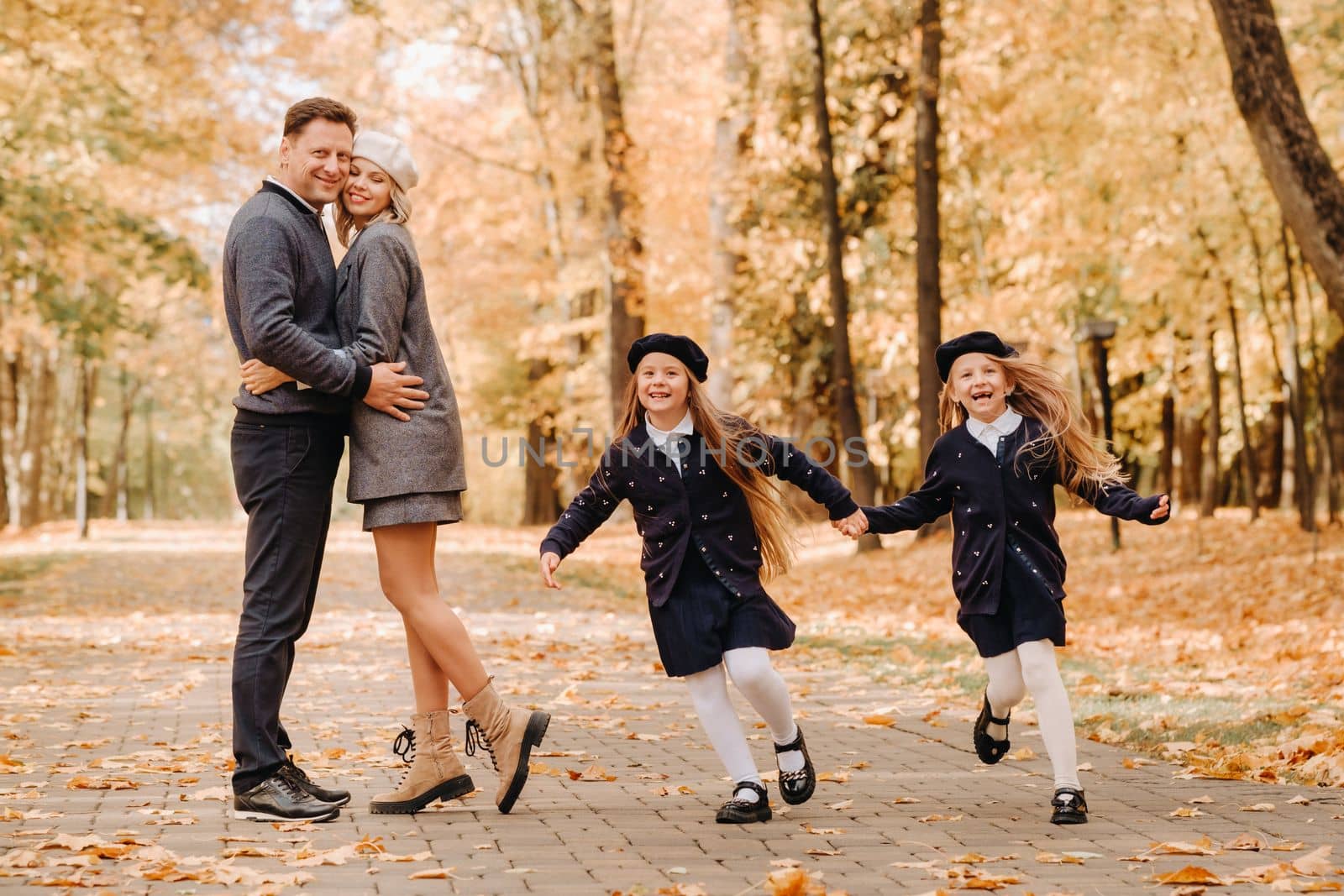 A large family walks in the park in the fall. Happy people in the autumn park.