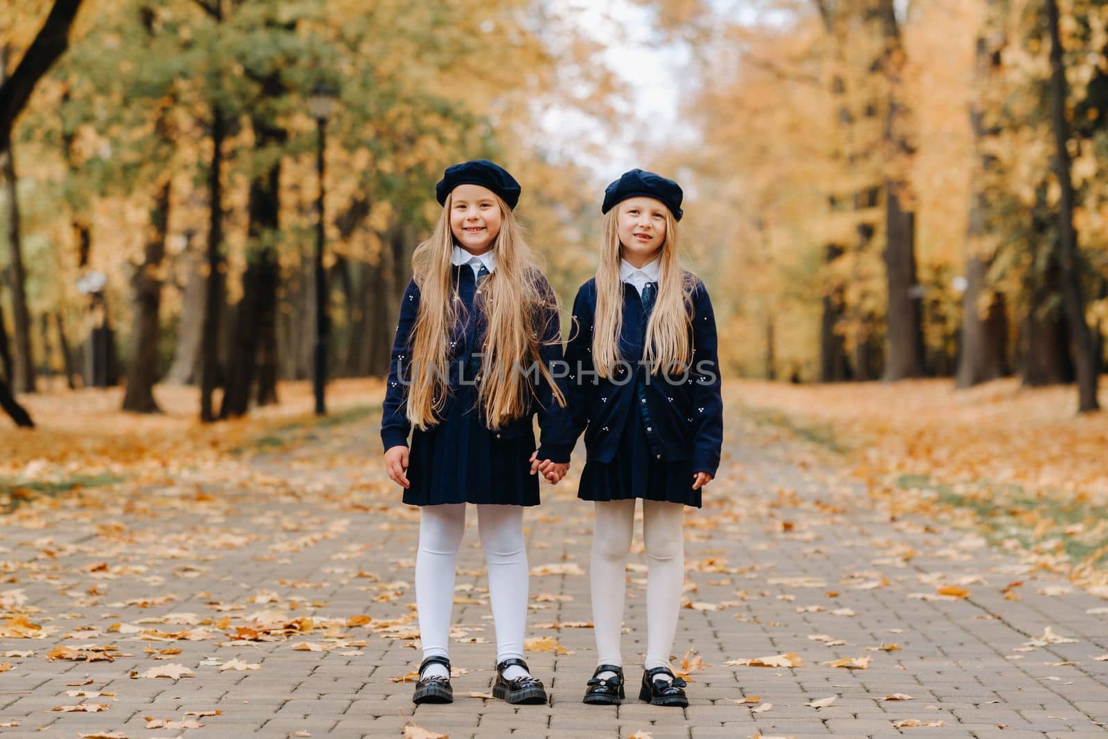 Happy children holding hands in a beautiful autumn park.