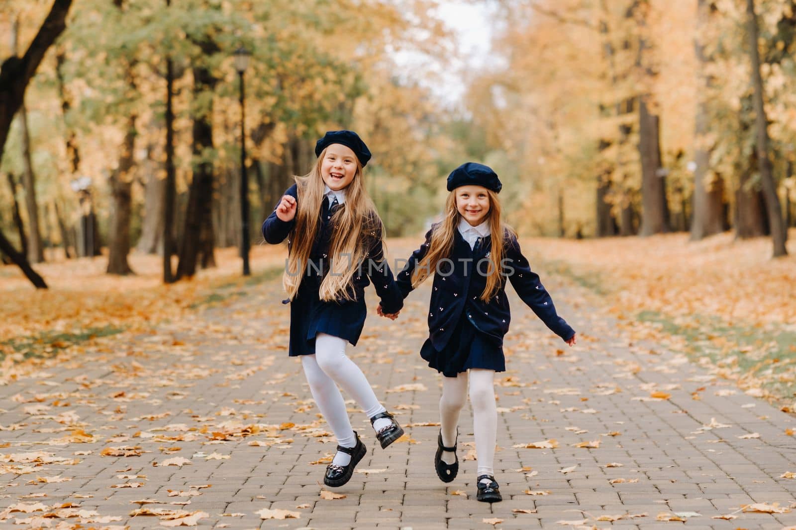 Happy children are running in a beautiful autumn park.