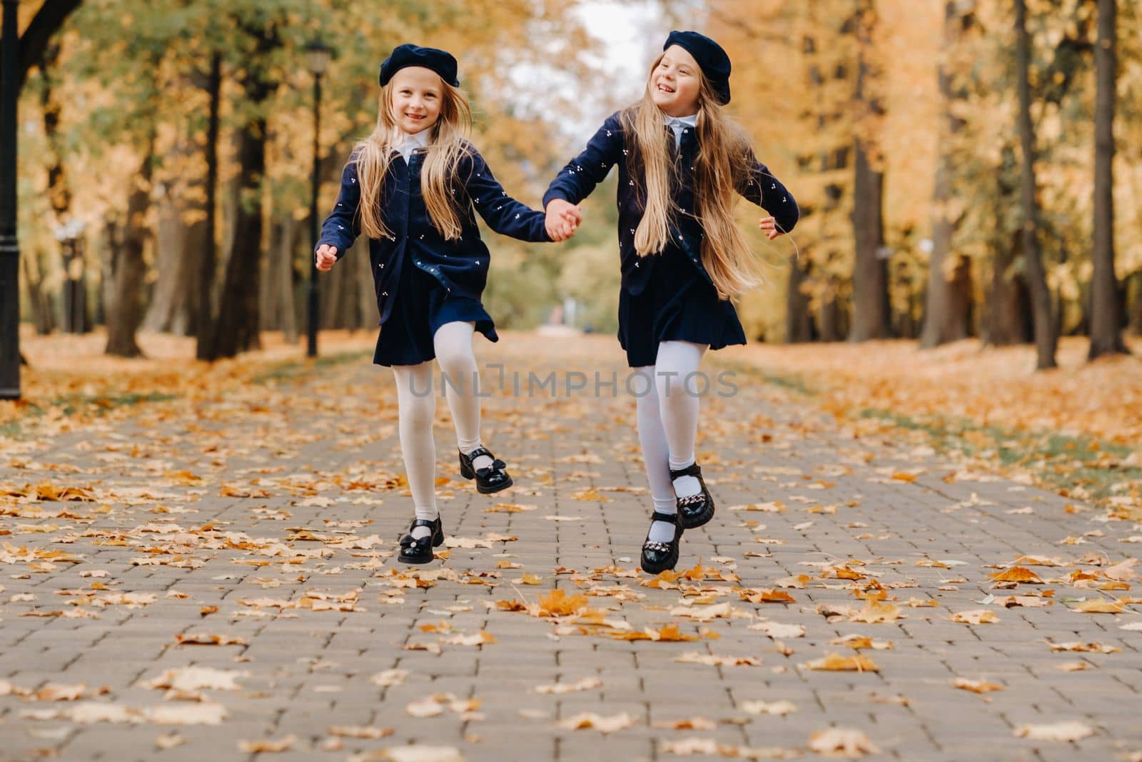 Happy children are running in a beautiful autumn park.