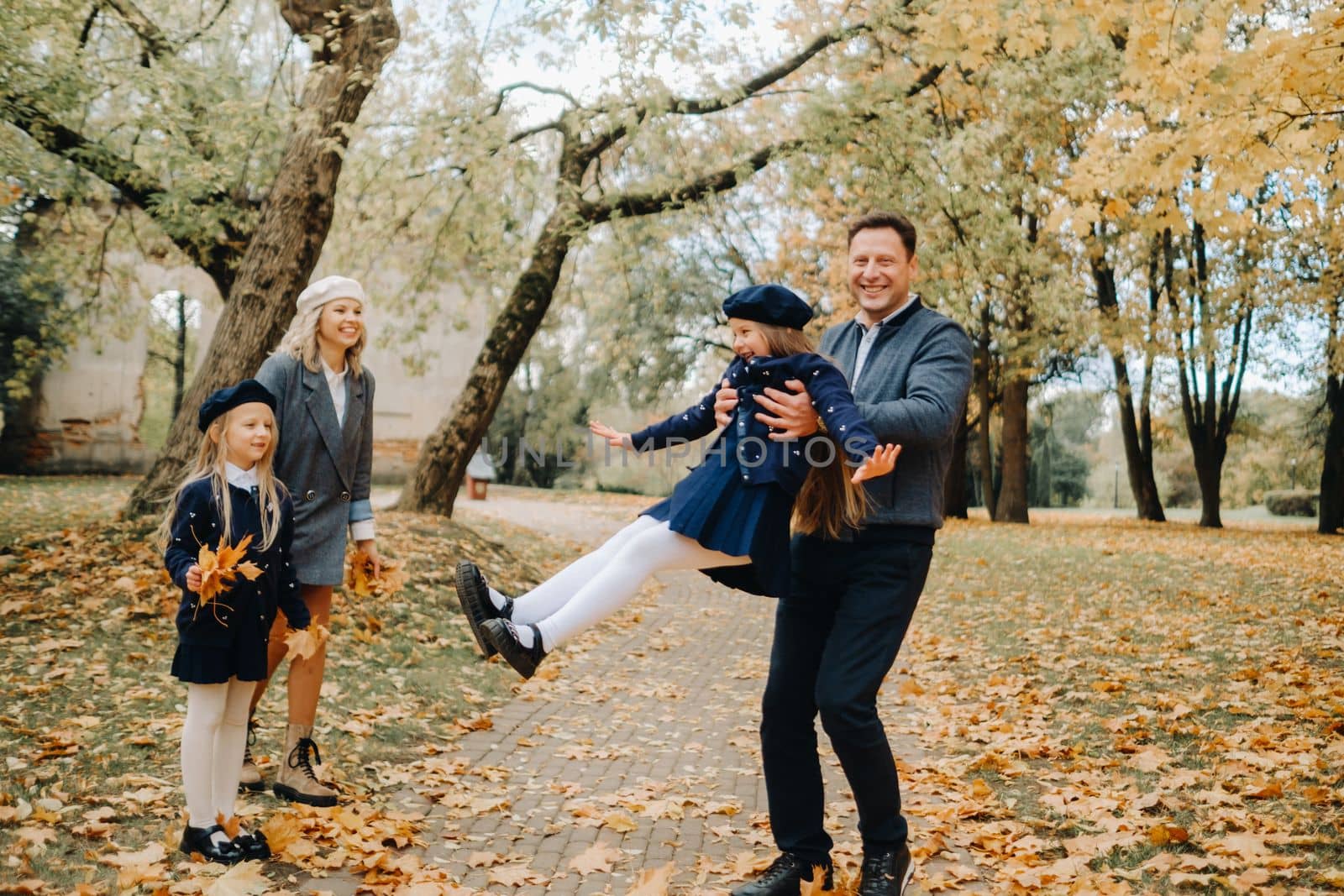 A large family walks in the park in the fall. Happy people in the autumn park.