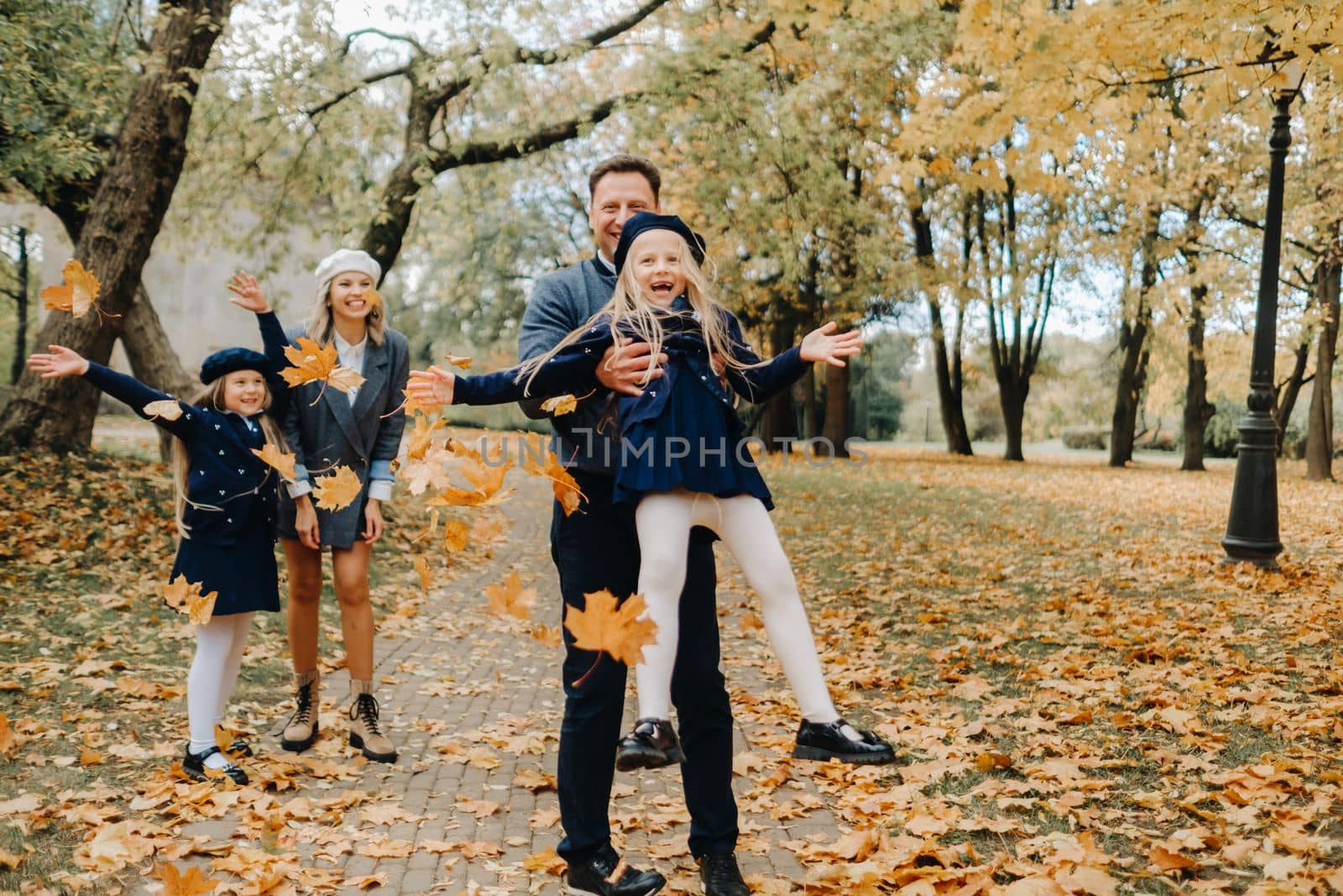 A large family walks in the park in the fall. Happy people in the autumn park.