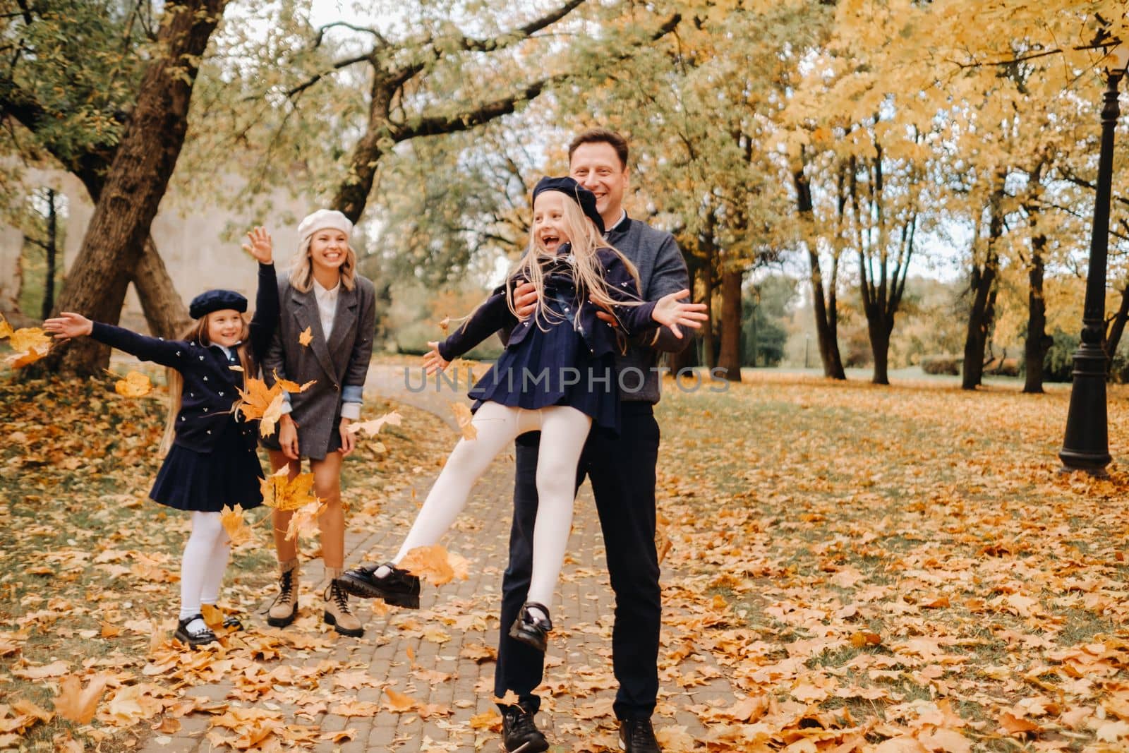 A large family walks in the park in the fall. Happy people in the autumn park.