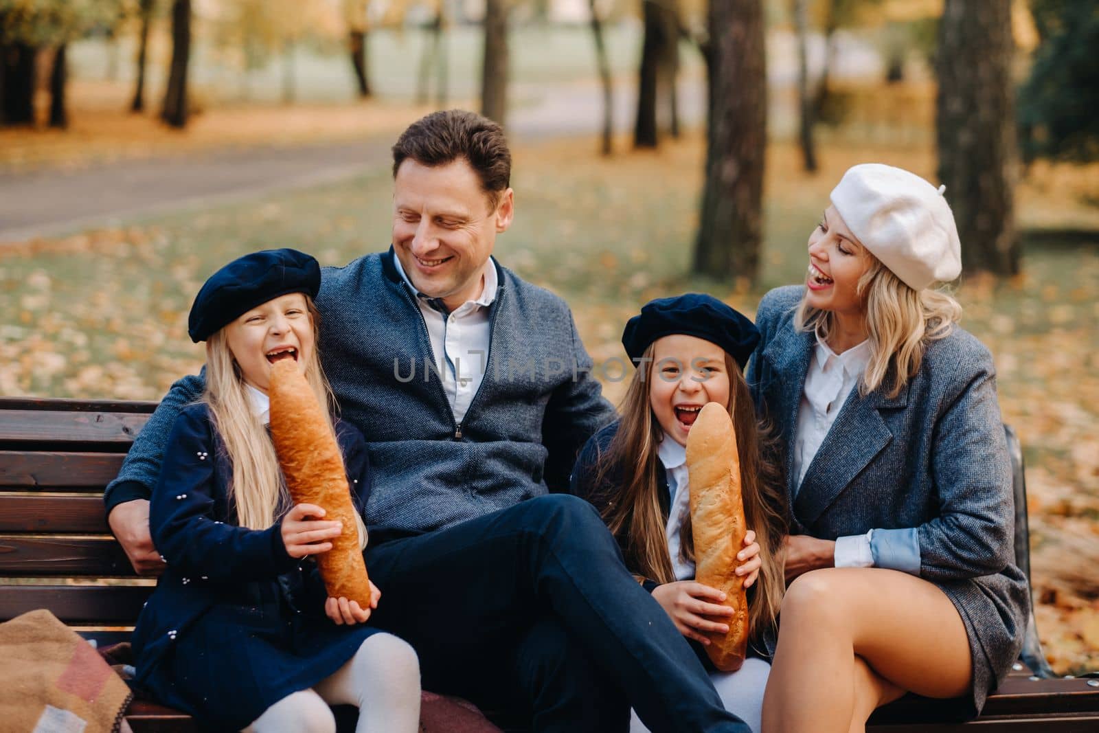 A large family is sitting on a bench in an autumn park. Happy people in the autumn park.