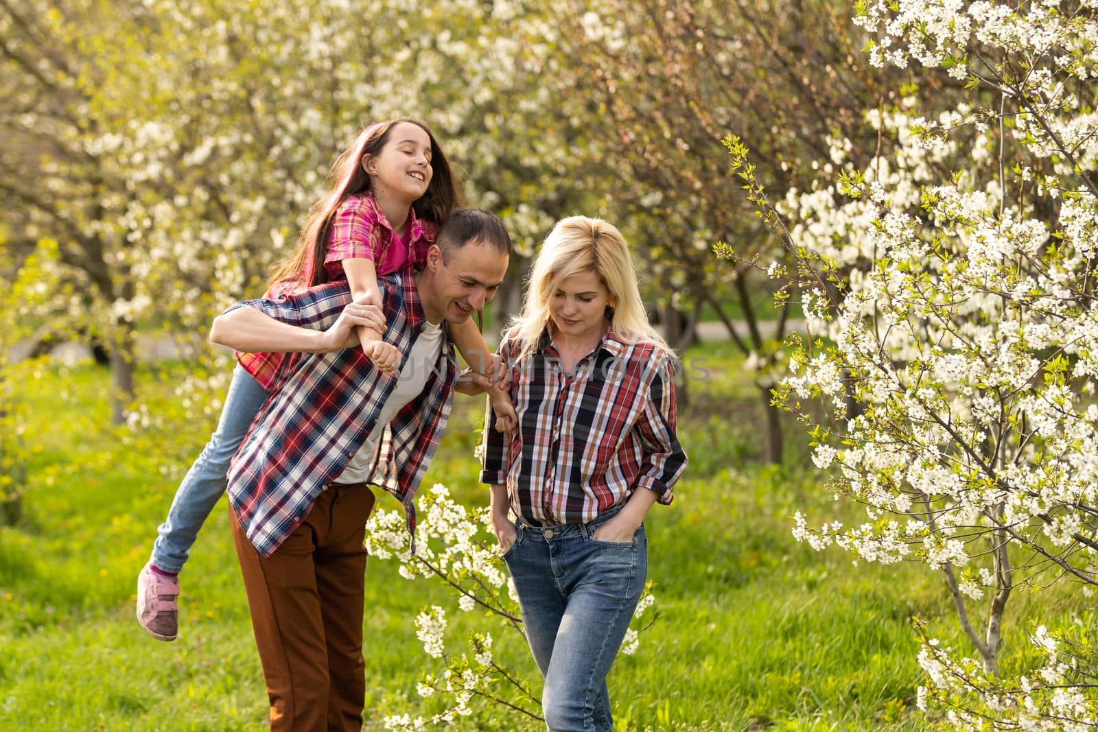 Happy young family spending time together outside in green nature.