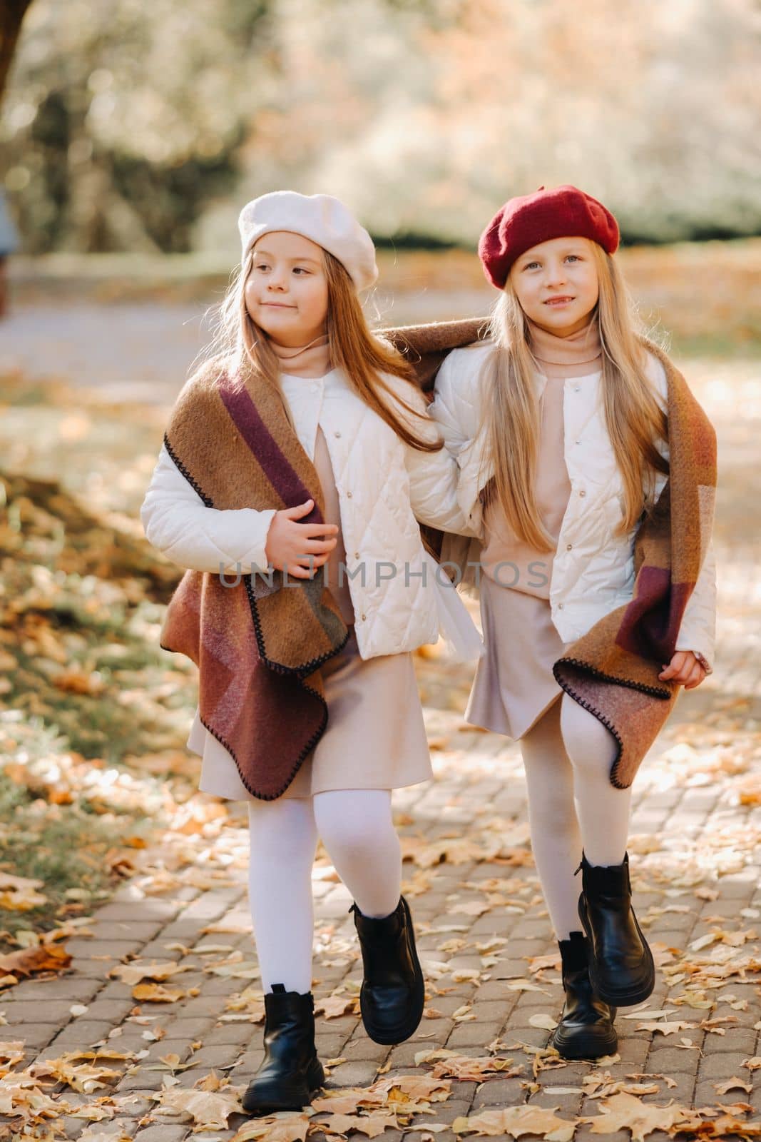 Happy children cuddling in a beautiful autumn park by Lobachad