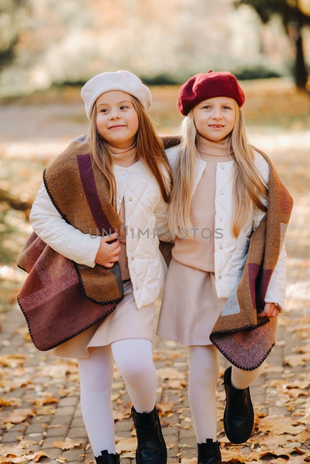 Happy children cuddling in a beautiful autumn park by Lobachad