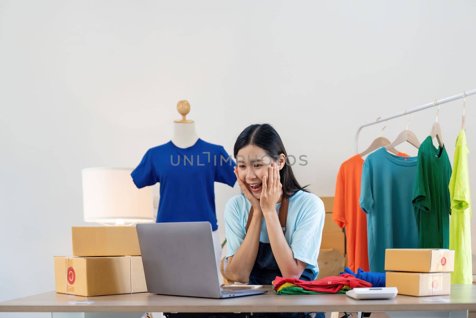Happy exciting successful asian woman doing clothing business selling online. she using laptop computer. online sell marketing delivery, SME e-commerce telemarketing concept.