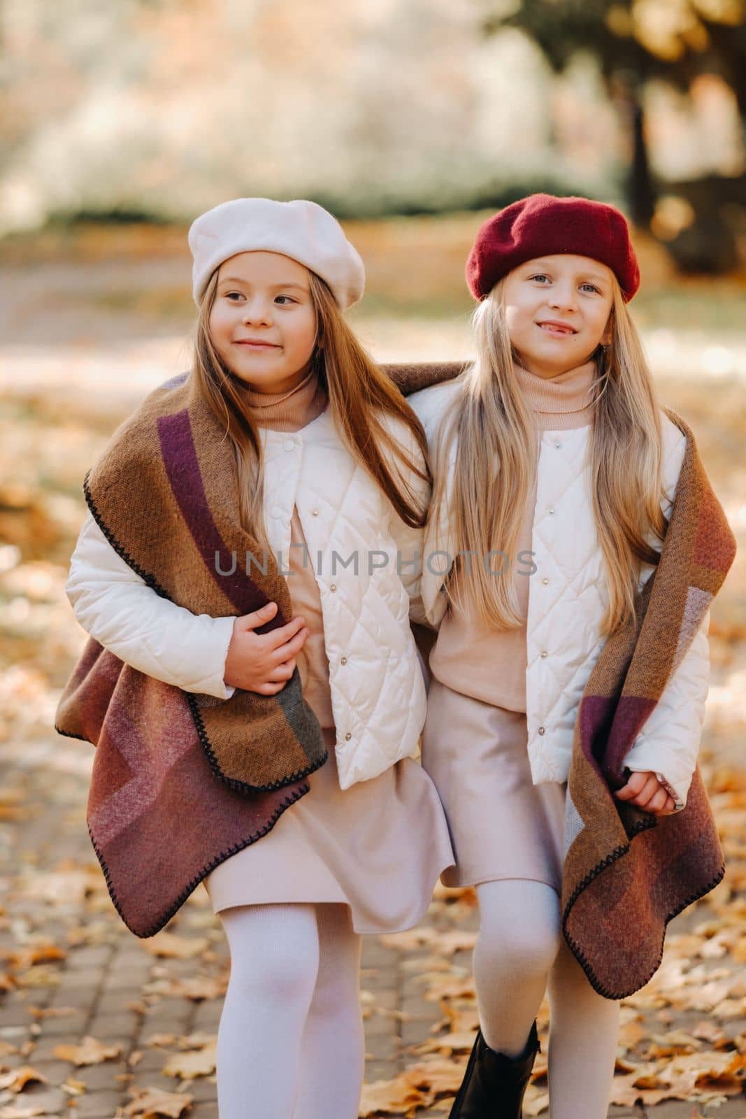 Happy children cuddling in a beautiful autumn park by Lobachad