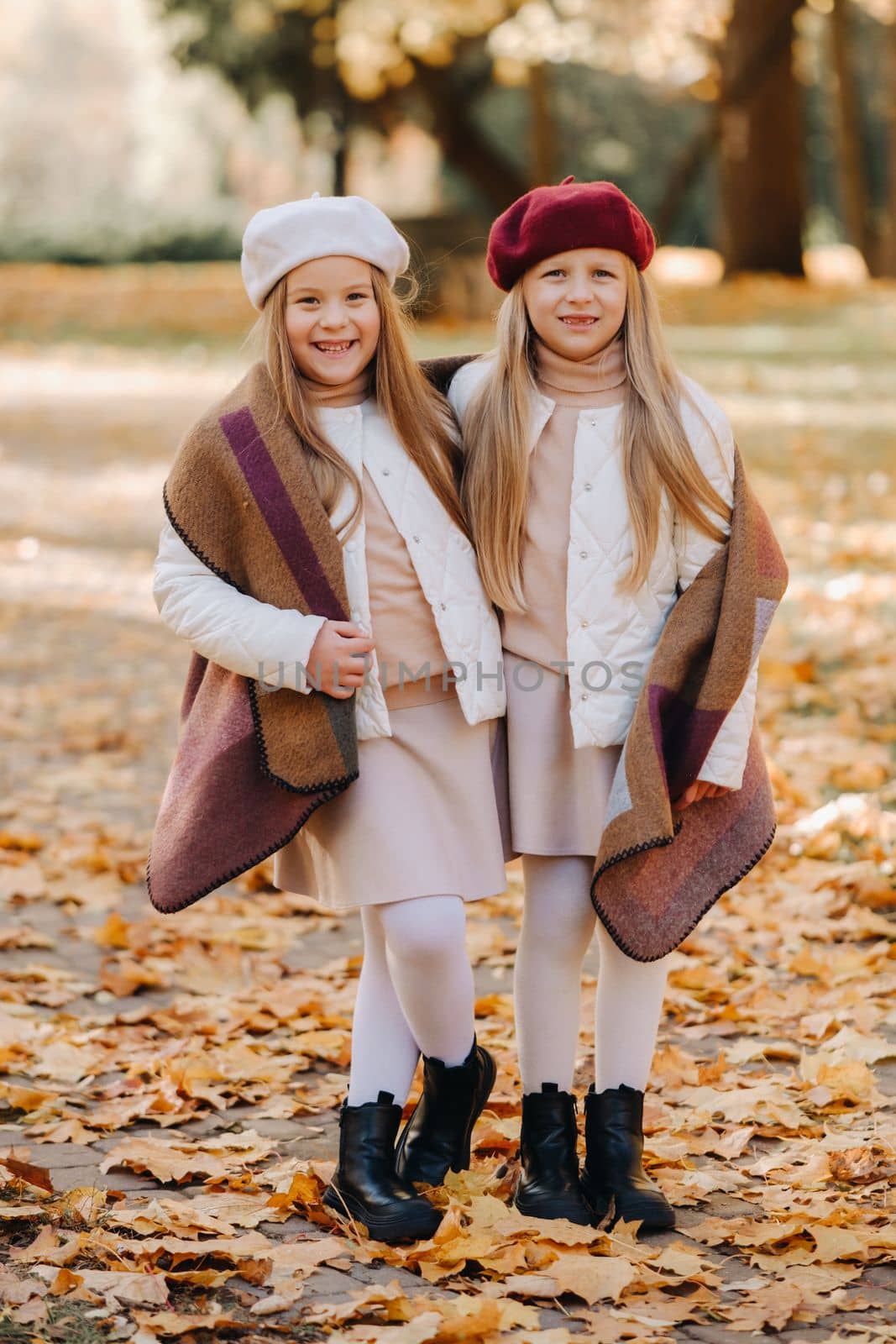 Happy children cuddling in a beautiful autumn park by Lobachad