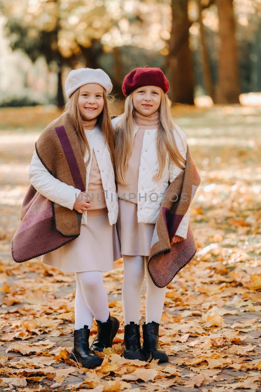 Happy children cuddling in a beautiful autumn park by Lobachad