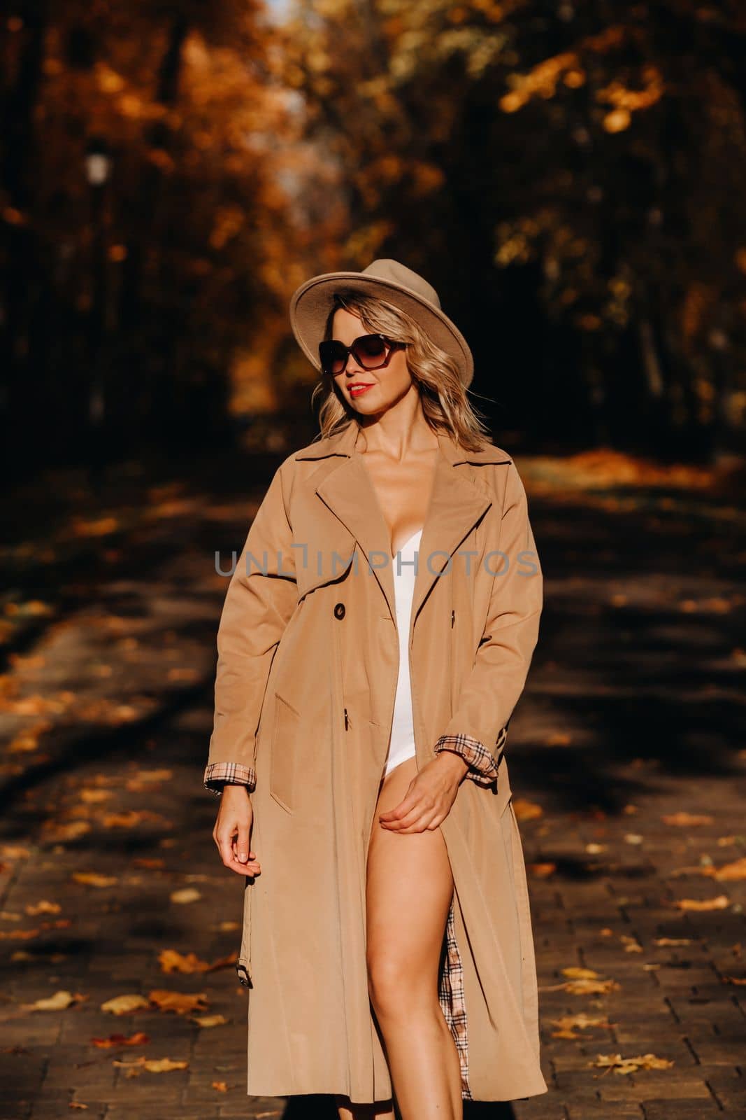 Sexy girl in a coat and hat in an autumn sunny park by Lobachad