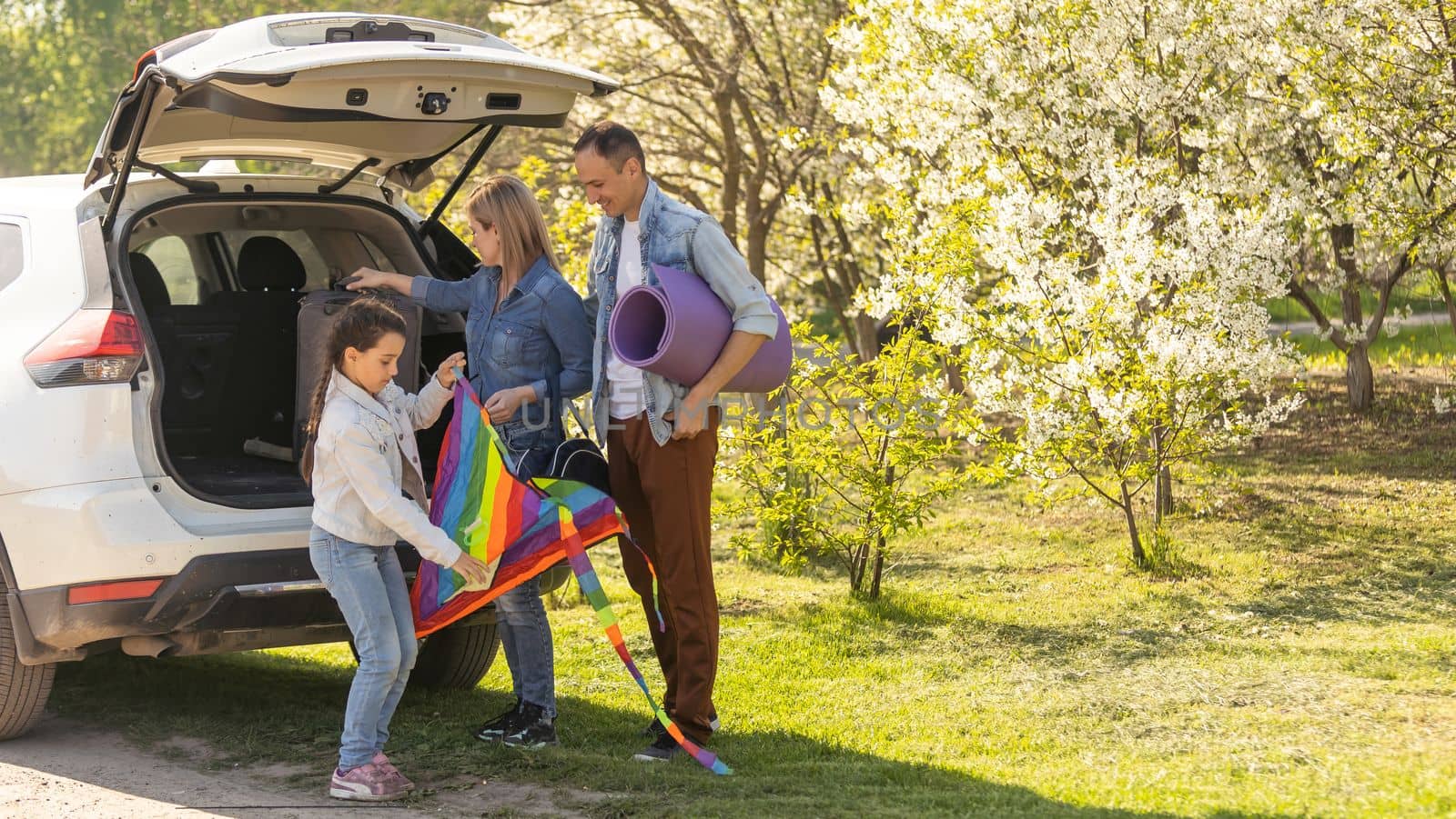 Family Enjoying. happy little girl with family near the car. Car insurance concept by Andelov13