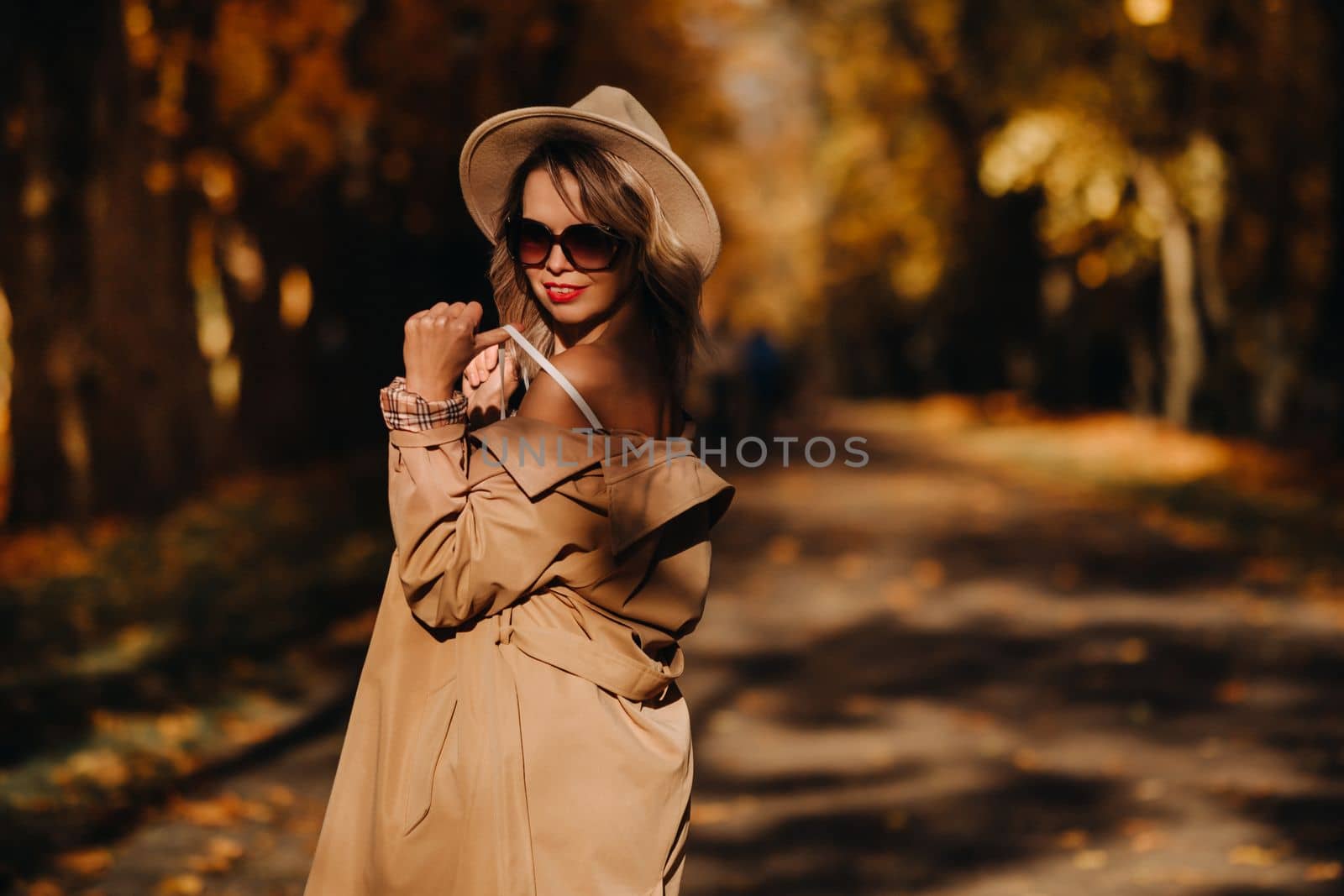 Sexy girl in a coat and hat in an autumn sunny park by Lobachad