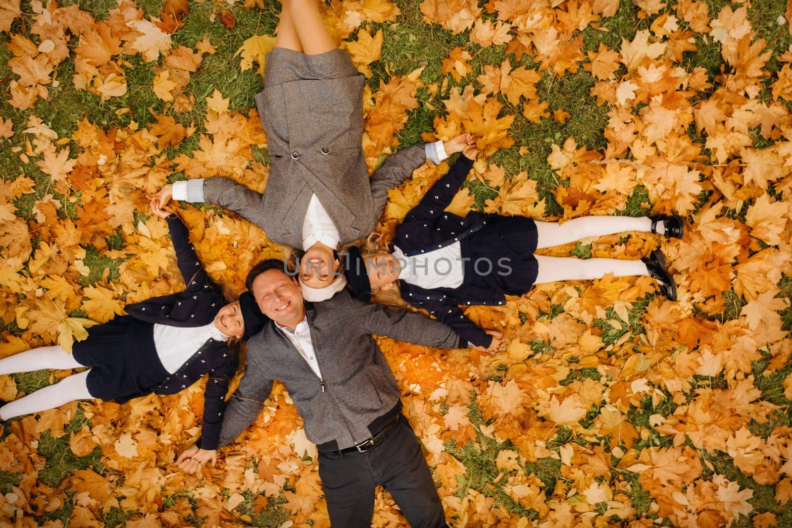A large family holding hands are lying in an autumn park .Happy people in the autumn park.