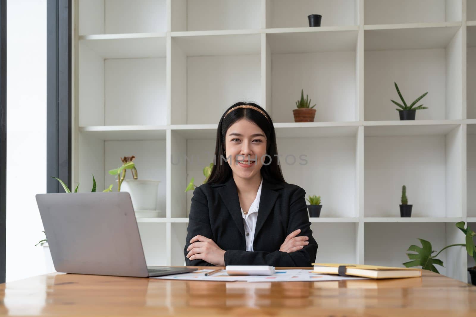 Portrait confidence asian business woman looking on camera sitting at work desk in office