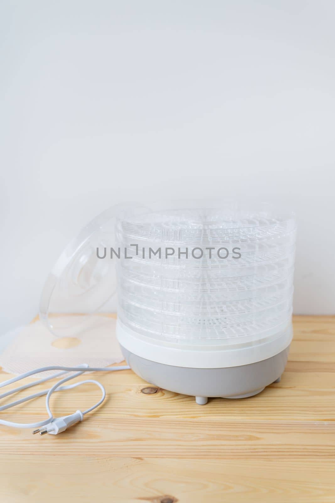 The process of homemade dried fruit or candied fruit in an electric dryer on the table. Fruits for storage and consumption in winter