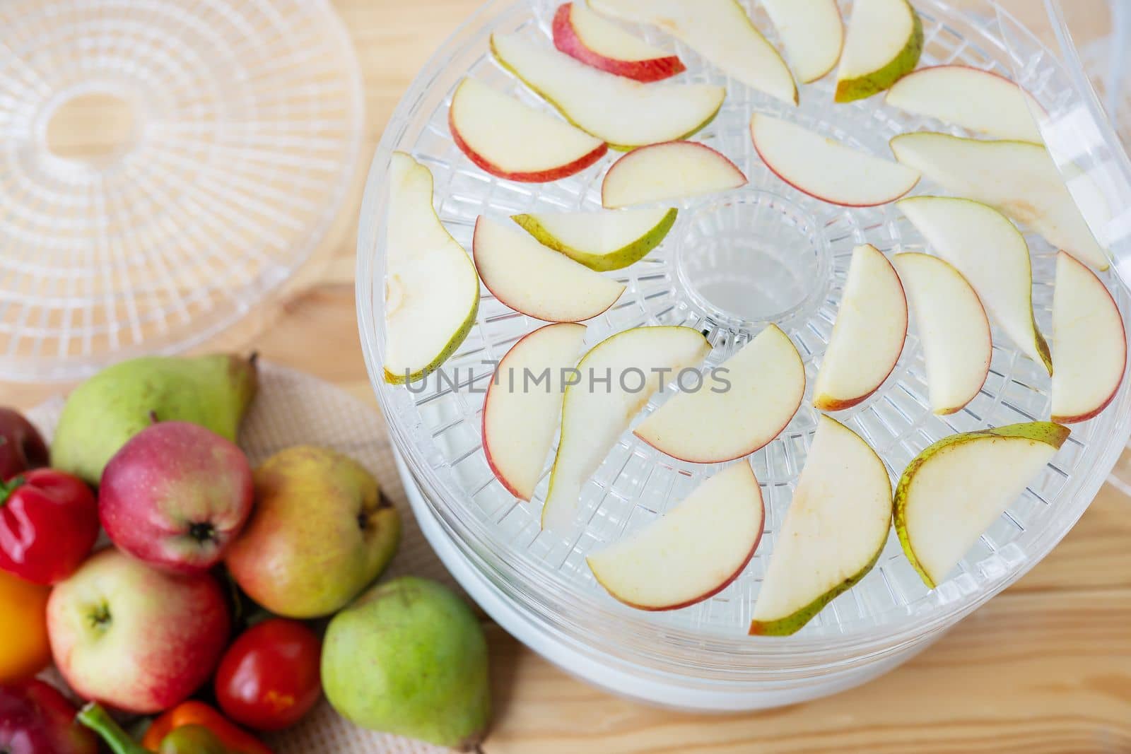 Electric drying machine for dehydrating products with horizontal loading of pallets. Apples and pears on pallets. Top view, close-up, natural light