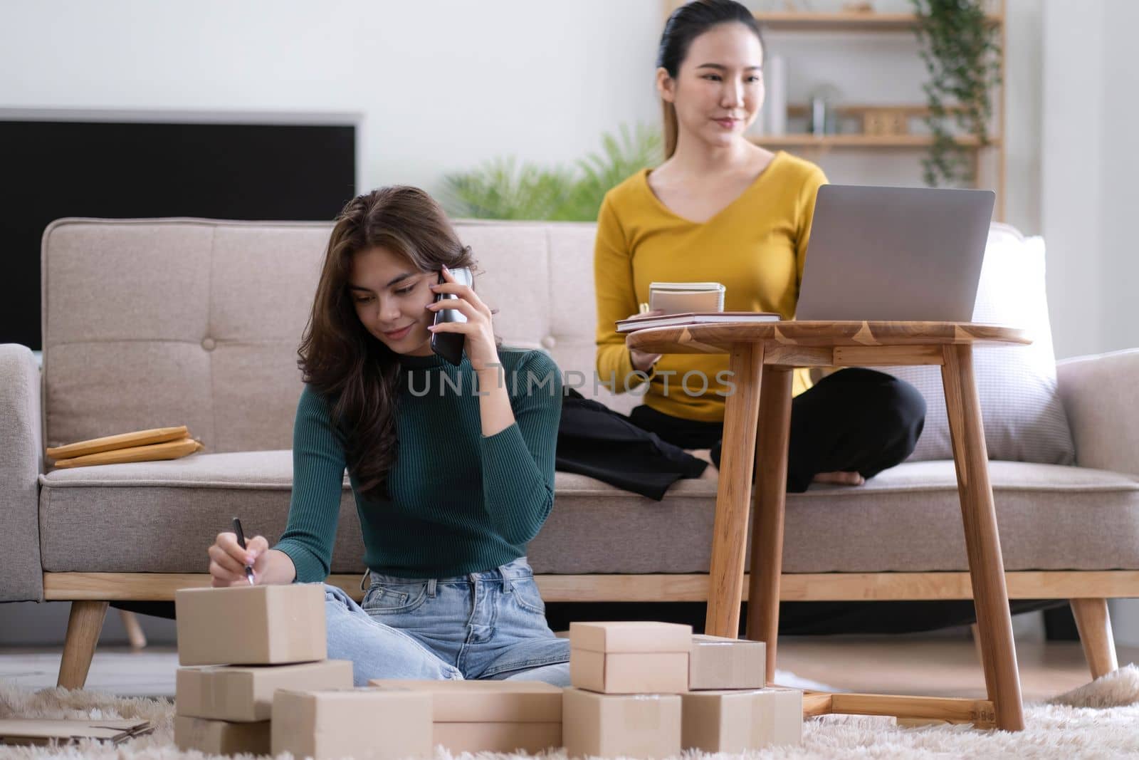 Portrait of Starting small businesses SME owners, two Asian woman check online orders Selling products working with boxs freelance work at home office, sme business online small medium enterprise by wichayada