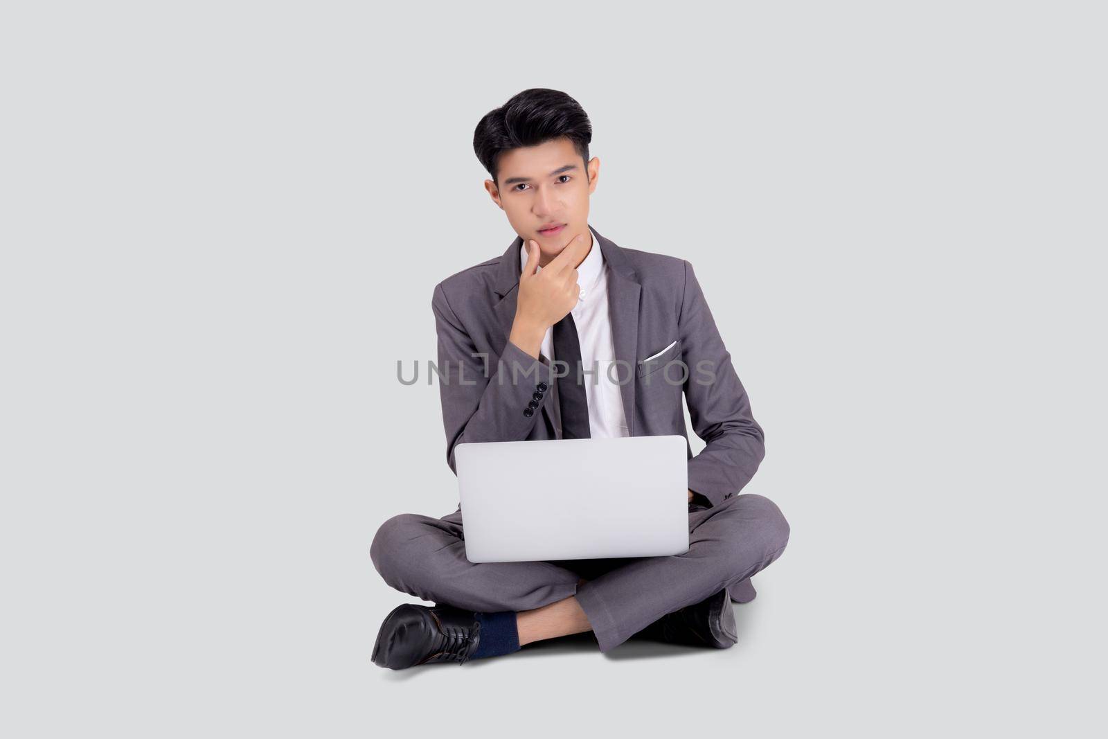 Young asian business man sitting thinking and work on laptop computer to internet online isolated on white background, businessman with notebook, freelance with success, marketing and communication.