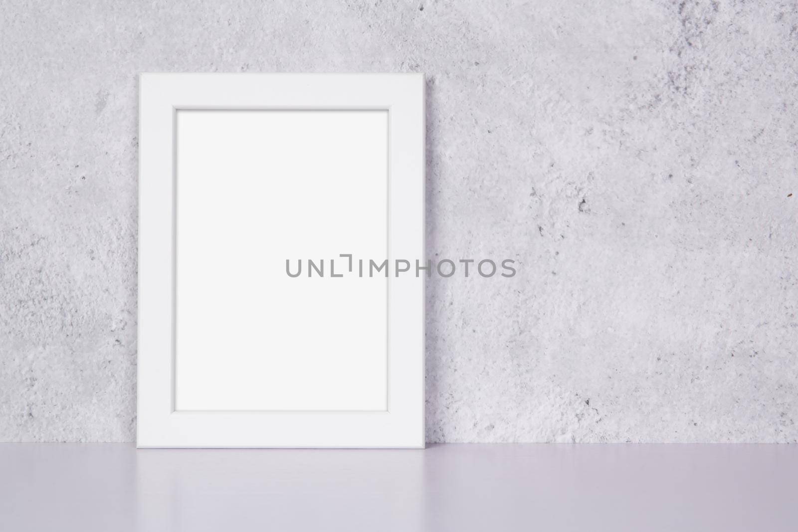 Mockup white frame vertical on table top and wall at home, mock up poster for presentation on desk, your design for gallery photo and picture image, border template and decoration for advertising. by nnudoo