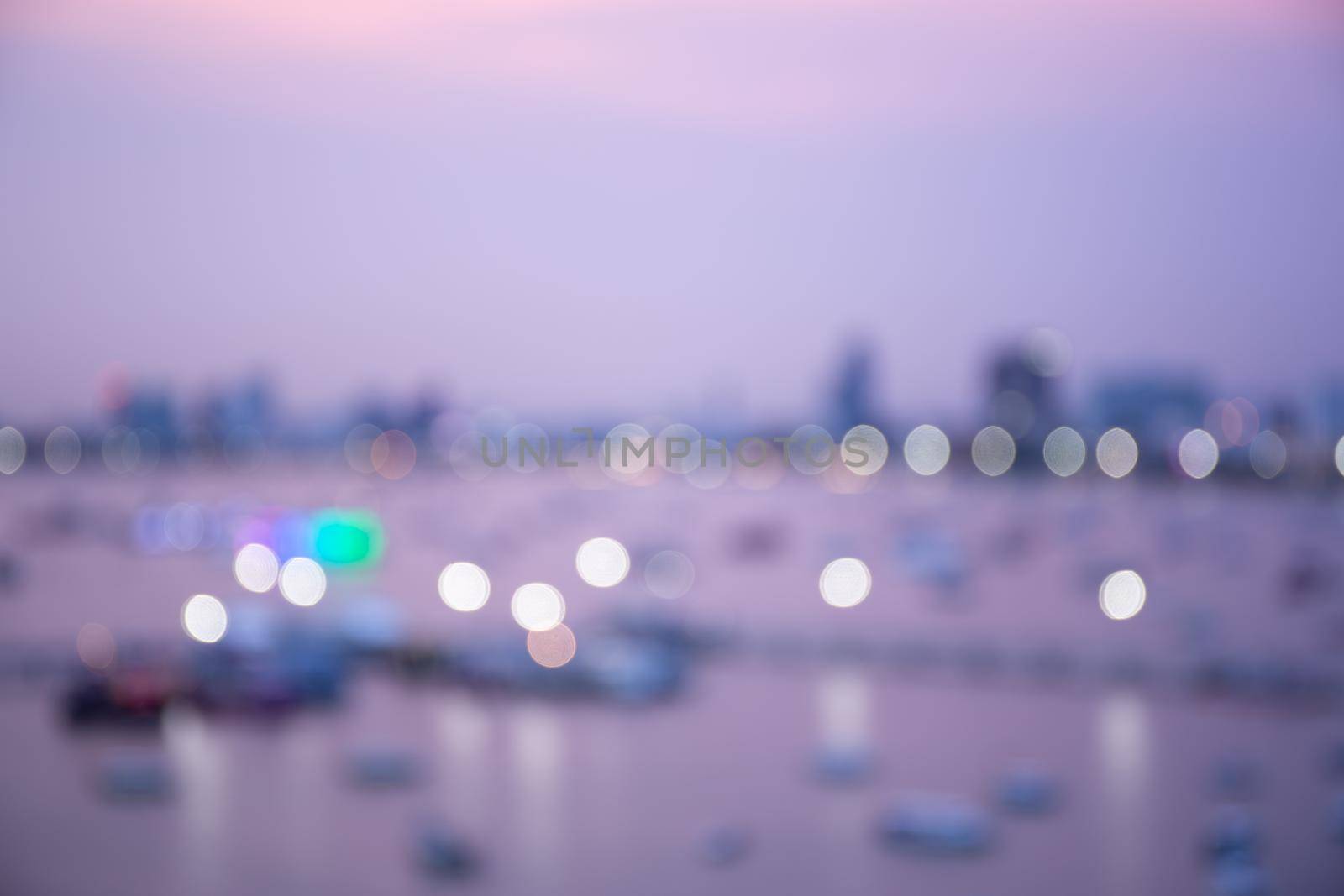Blur bokeh background with cityscape in twilight, blurred focus in evening with downtown, landscape, illuminated and light.