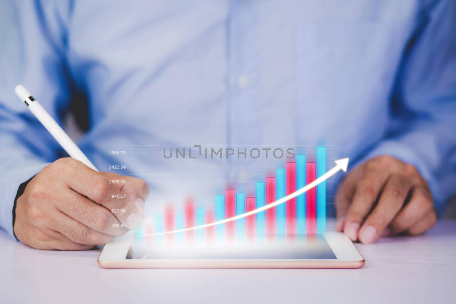 Businessman holding pen with graph and chart of investment and finance on tablet computer, growth of stock and profit, digital marketing, planning of financial, business and communication concepts. by nnudoo