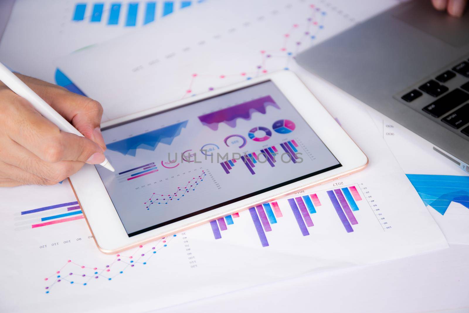 Businessman planning about graph and chart of investment with report for finance on tablet computer on desk, statistic for financial and profit with document, digital marketing, business concept.